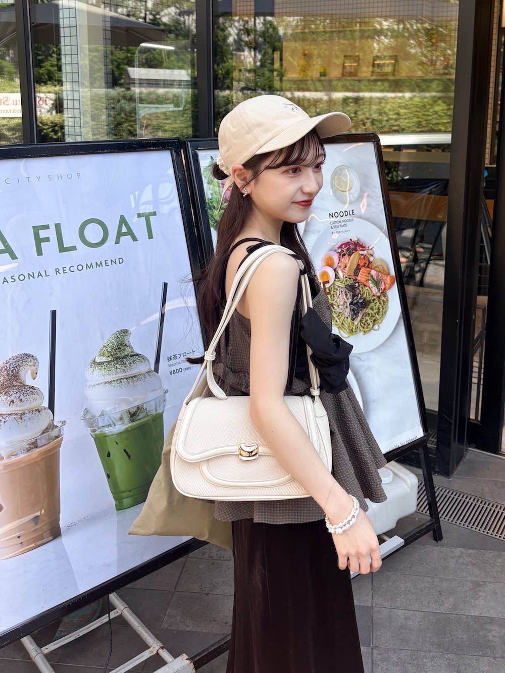ブラウン系のワンピース、ホワイト系のスニーカー、ブラウン系のシャツ/ブラウスを着用したレディースの秋コーディネートの2枚目の写真