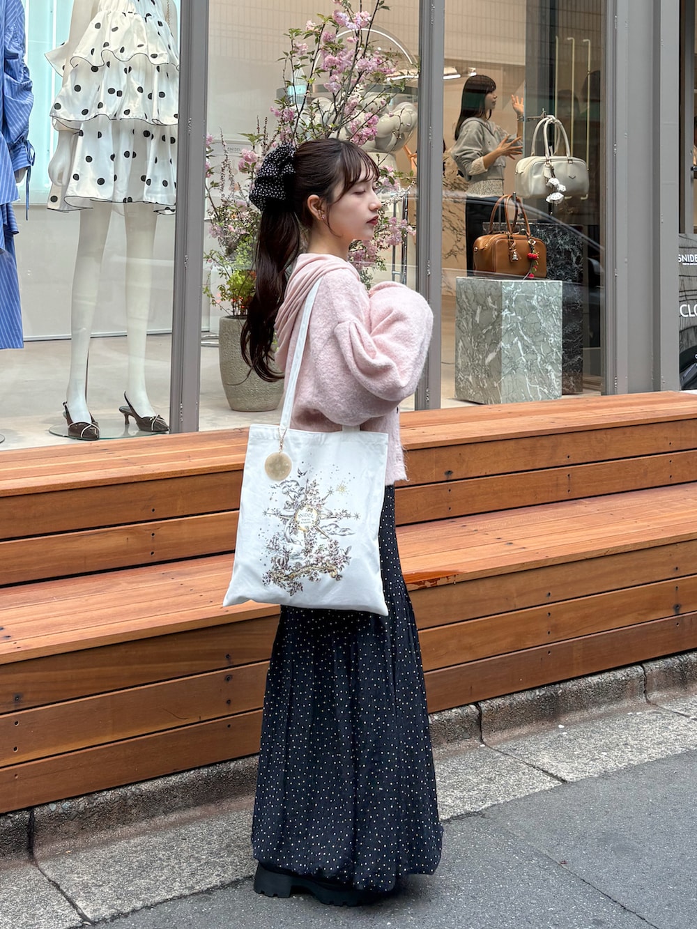 ホワイト系のスカート、ピンク系のカーディガン/ボレロ、ホワイト系のパーカーを着用したレディースの春コーディネートの2枚目の写真