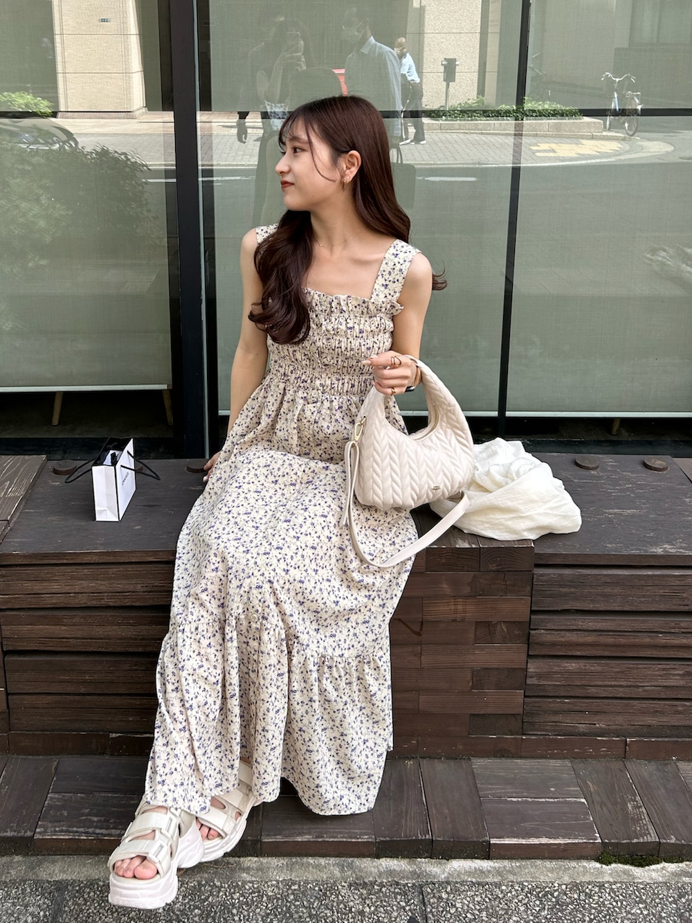 イエロー系のワンピース、ホワイト系のショルダーバッグ、ホワイト系のサンダルを着用したレディースの夏コーディネートの3枚目の写真