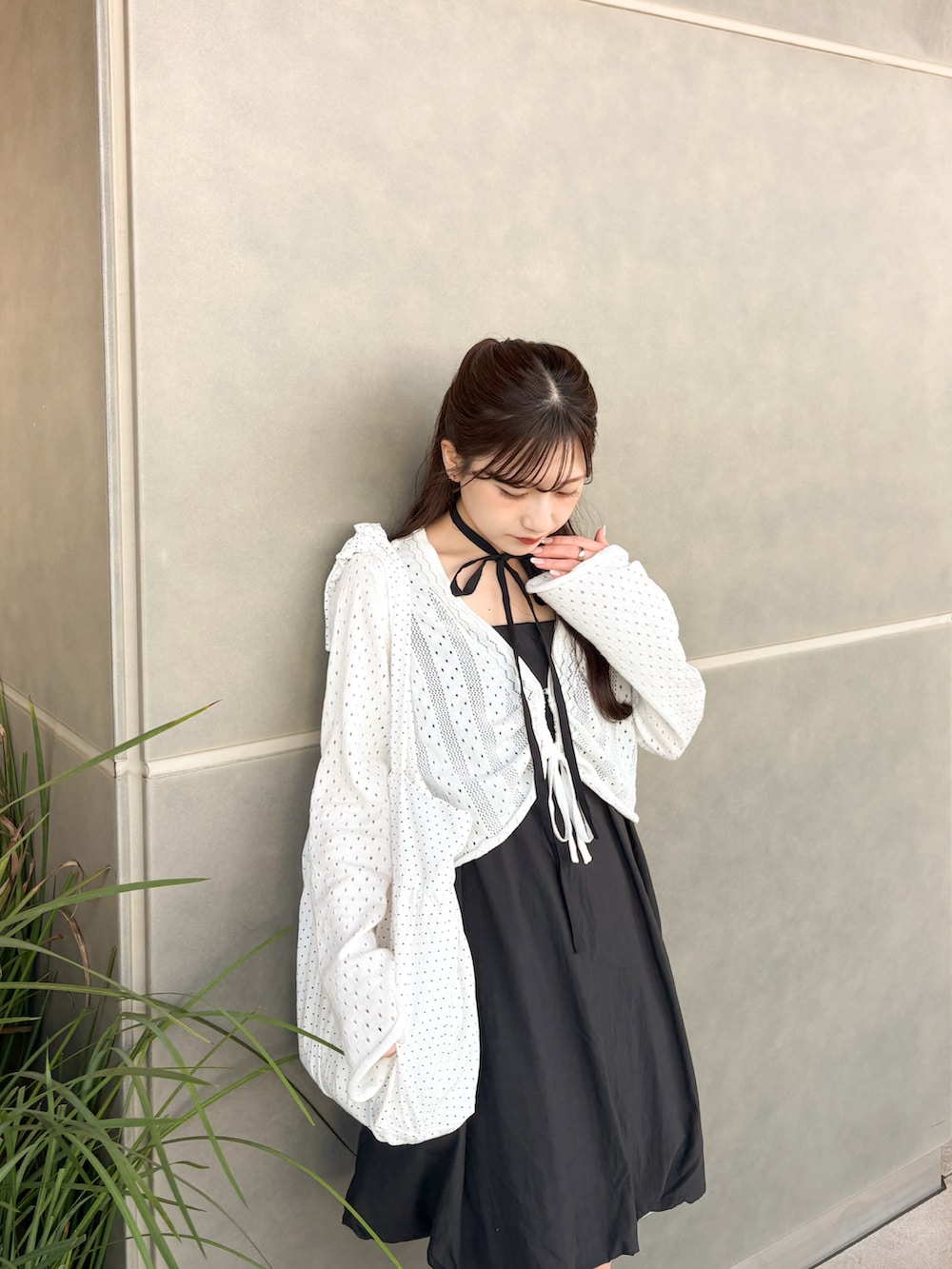 ブラック系のワンピース、ブラック系のブーツ、ホワイト系のカーディガン/ボレロを着用したレディースの夏コーディネートの5枚目の写真