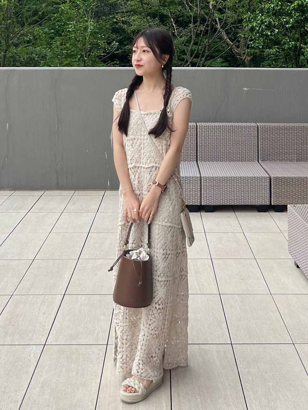 ブラウン系のハンドバッグ、ホワイト系のワンピース、ホワイト系のサンダルを着用したレディースの夏コーディネートの4枚目の写真