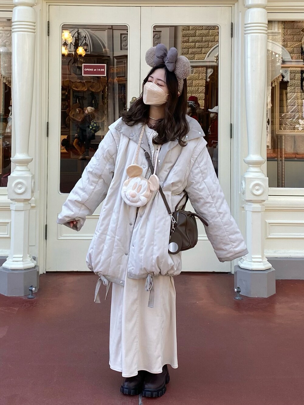 ベージュ系のショルダーバッグ、ホワイト系のダウンジャケット/コート、ホワイト系のニット/セーターを着用したレディースの冬コーディネートの3枚目の写真
