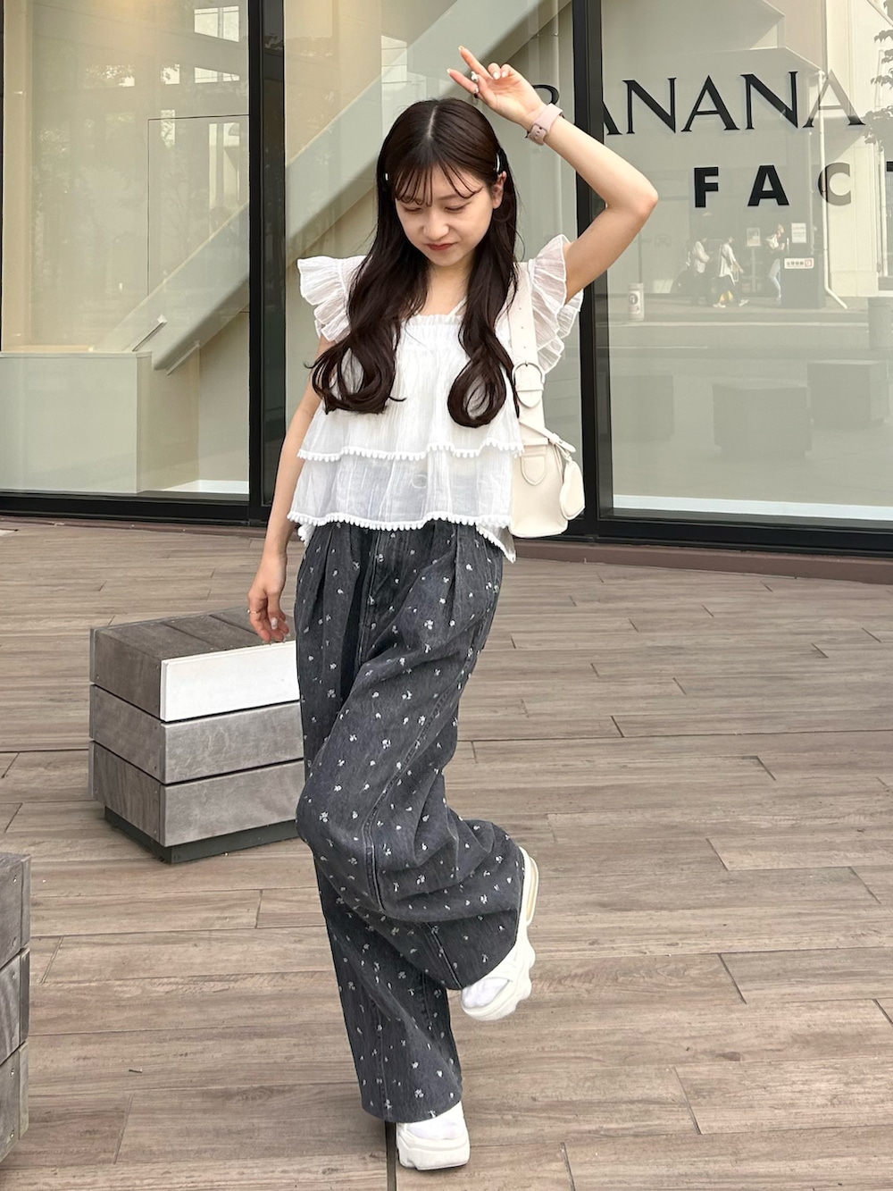 ブラック系のデニムパンツ、ホワイト系のキャミソール、ホワイト系のショルダーバッグを着用したレディースの春コーディネートの4枚目の写真