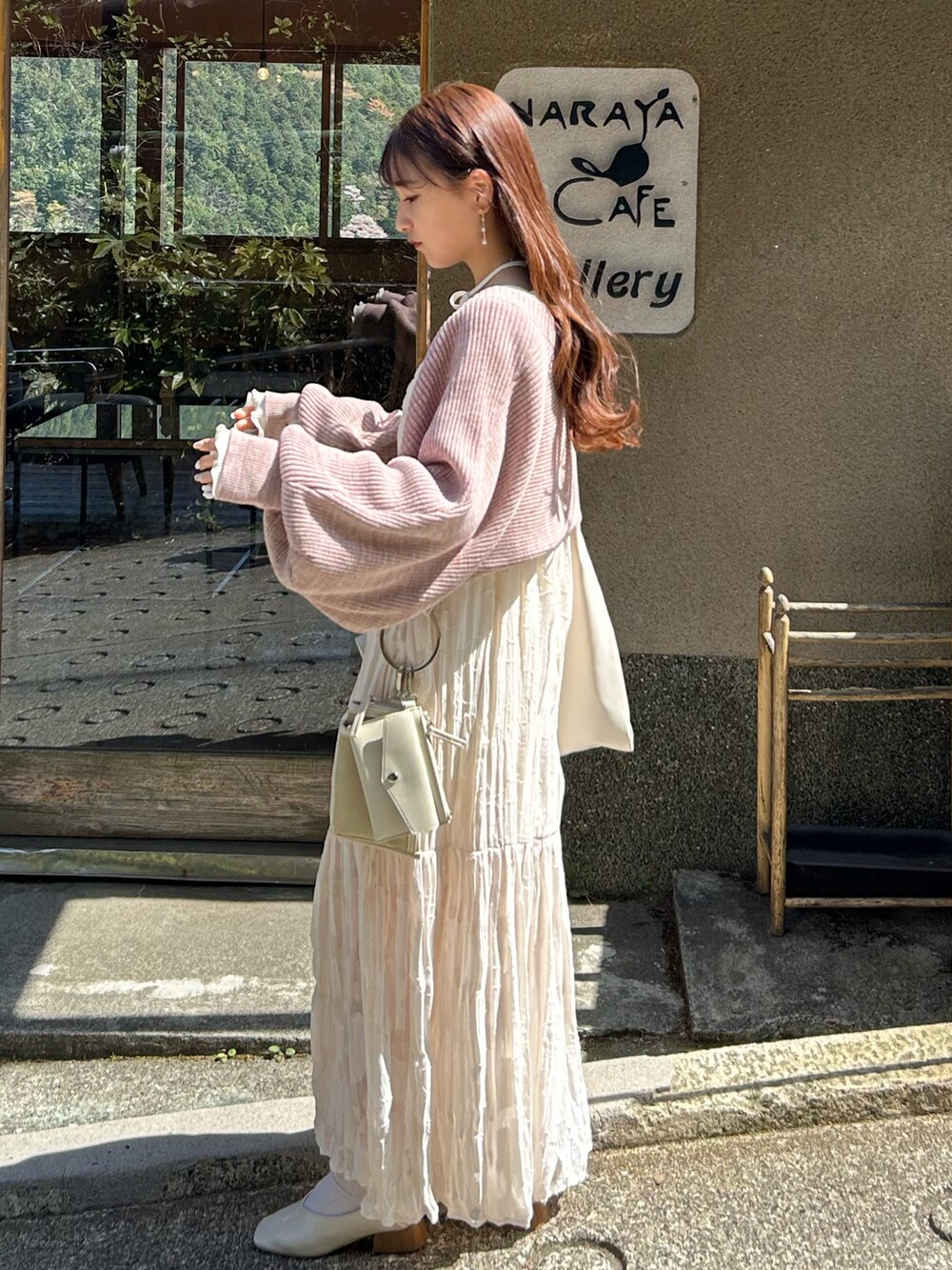 ホワイト系のワンピース、ベージュ系のショルダーバッグ、ピンク系のカーディガン/ボレロを着用したレディースの春コーディネートの3枚目の写真