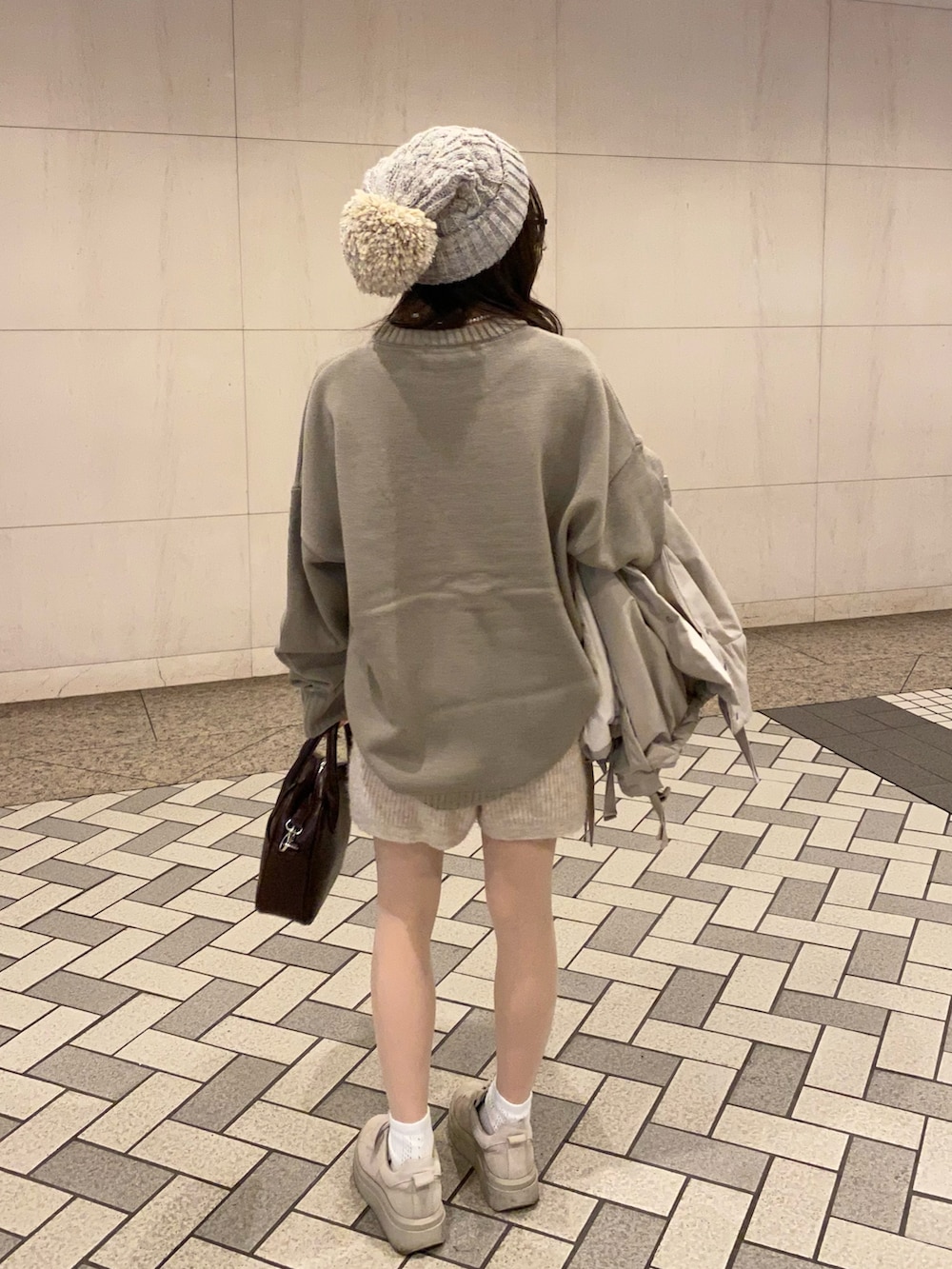 ブラウン系のショルダーバッグ、ベージュ系のスニーカー、ベージュ系のその他パンツを着用したレディースの冬コーディネートの2枚目の写真