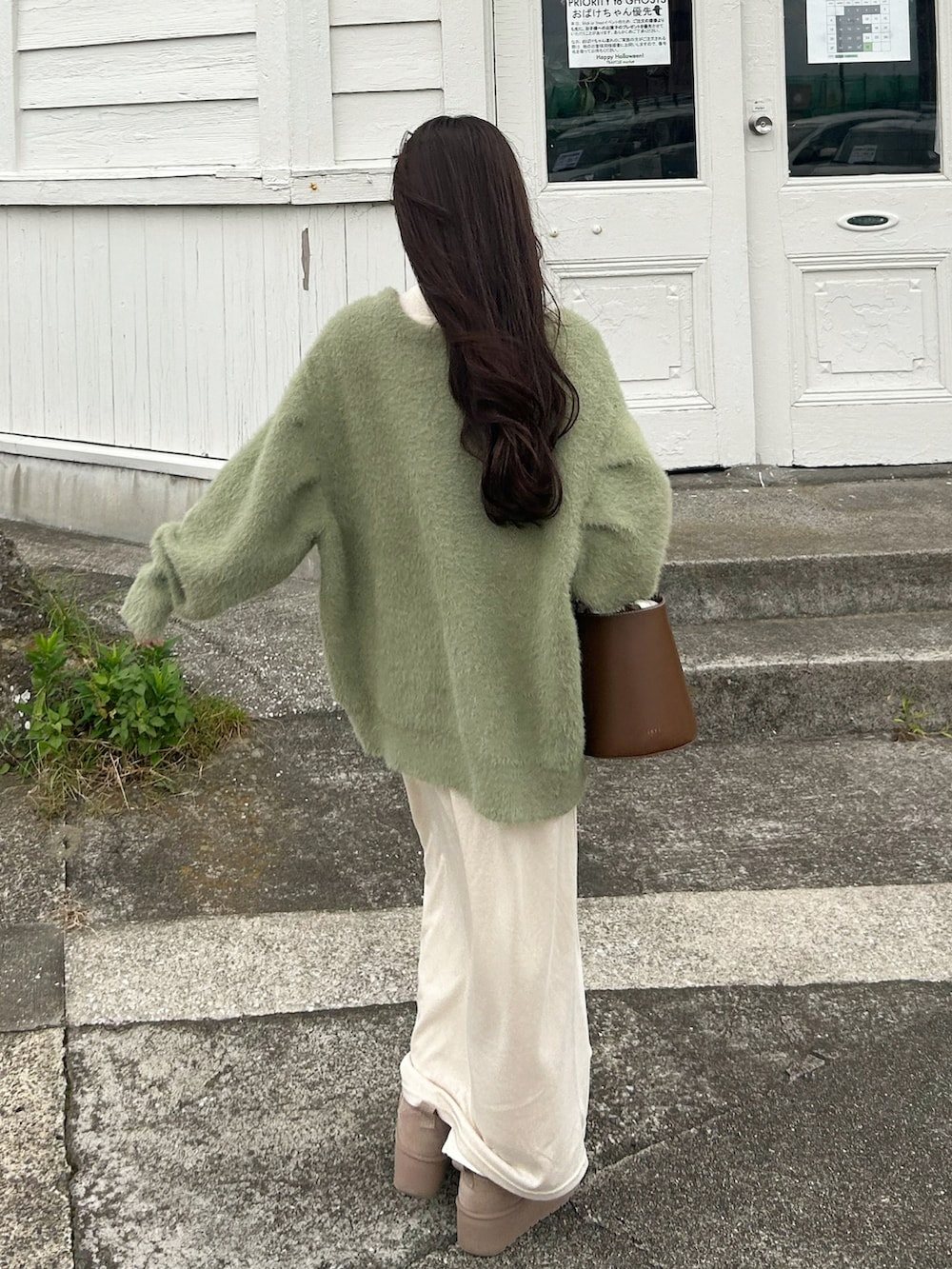 グリーン系のカーディガン/ボレロ、ブラウン系のハンドバッグ、ベージュ系のワンピースを着用したレディースの秋コーディネートの2枚目の写真