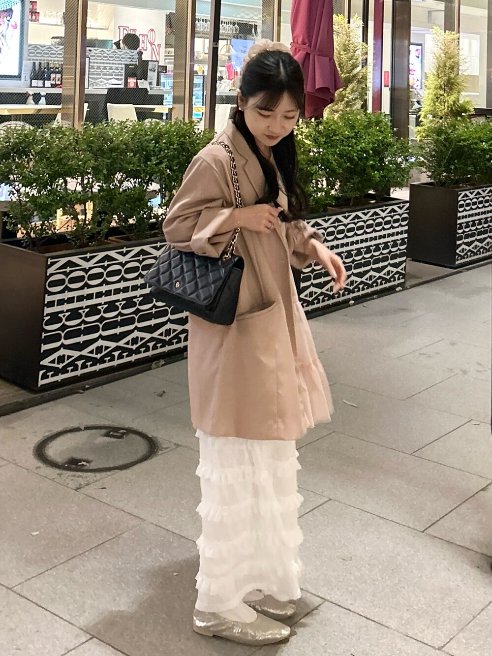 ピンク系のテーラードジャケット、シルバー系のパンプス、ホワイト系のスカートを着用したレディースの春コーディネートの2枚目の写真