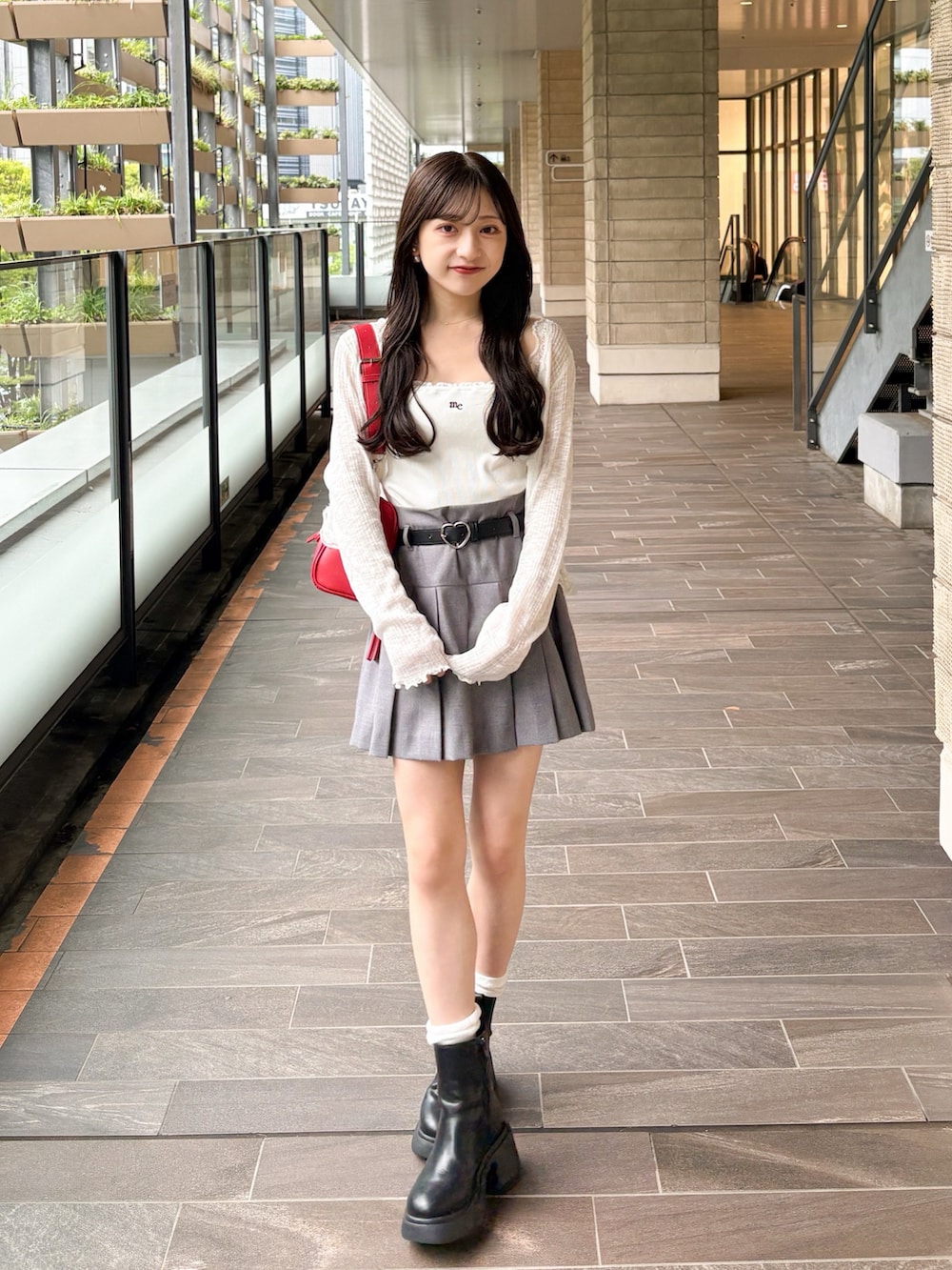 ホワイト系のキャミソール、ベージュ系のその他パンツ、ブラック系のブーツを着用したレディースの夏コーディネートの2枚目の写真