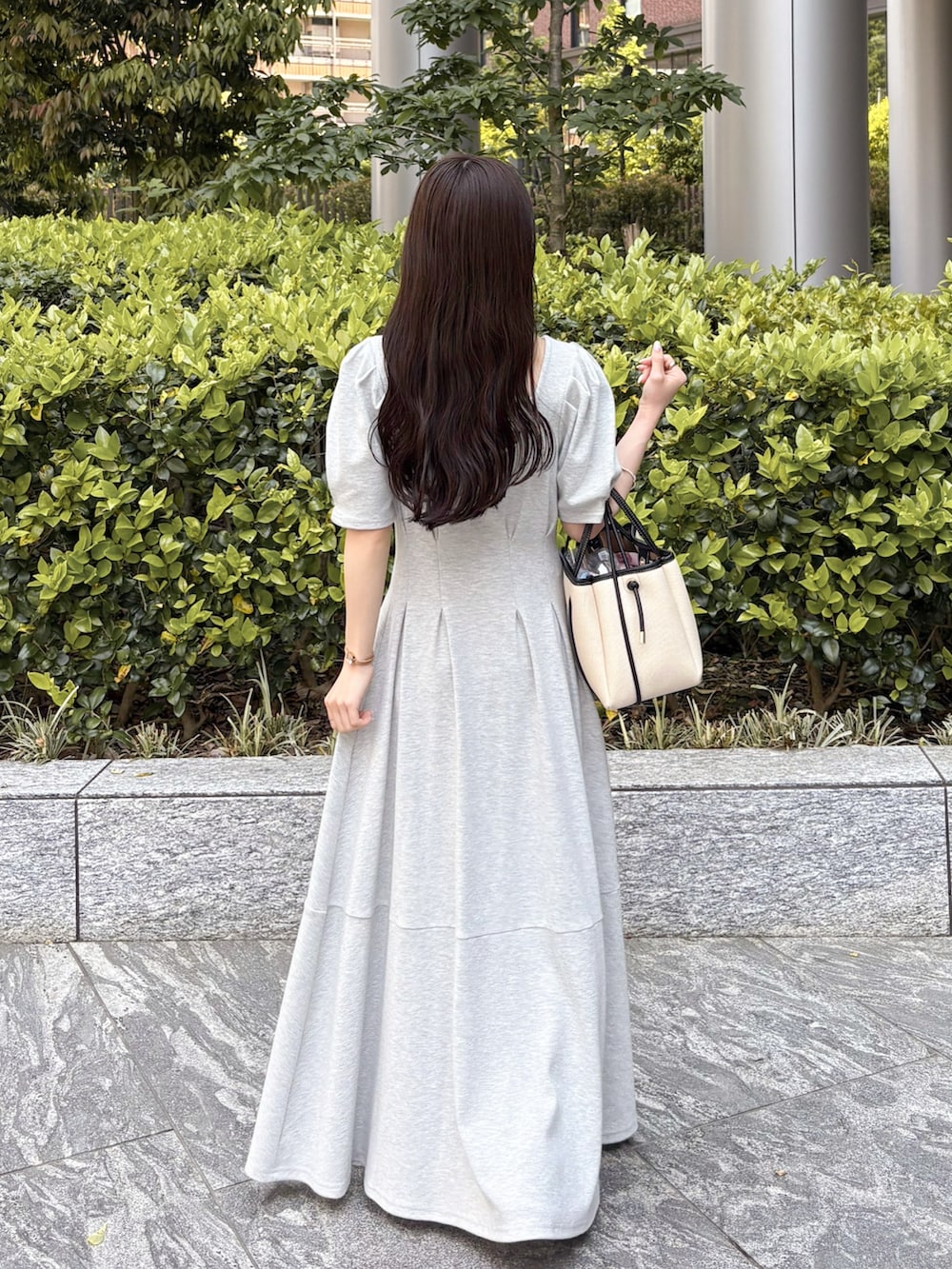グレー系のワンピース、ホワイト系のトートバッグを着用したレディースの春コーディネートの3枚目の写真