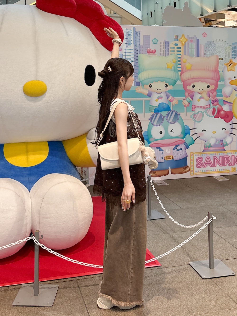 ホワイト系のタンクトップ、ブラウン系のデニムパンツ、ブラウン系のキャミソールを着用したレディースの夏コーディネートの2枚目の写真