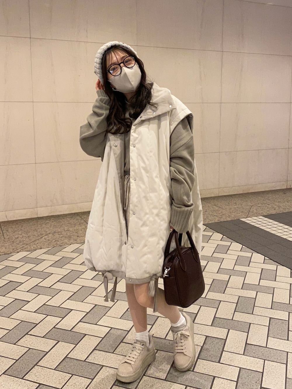 ブラウン系のショルダーバッグ、ベージュ系のスニーカー、ベージュ系のその他パンツを着用したレディースの冬コーディネートの3枚目の写真