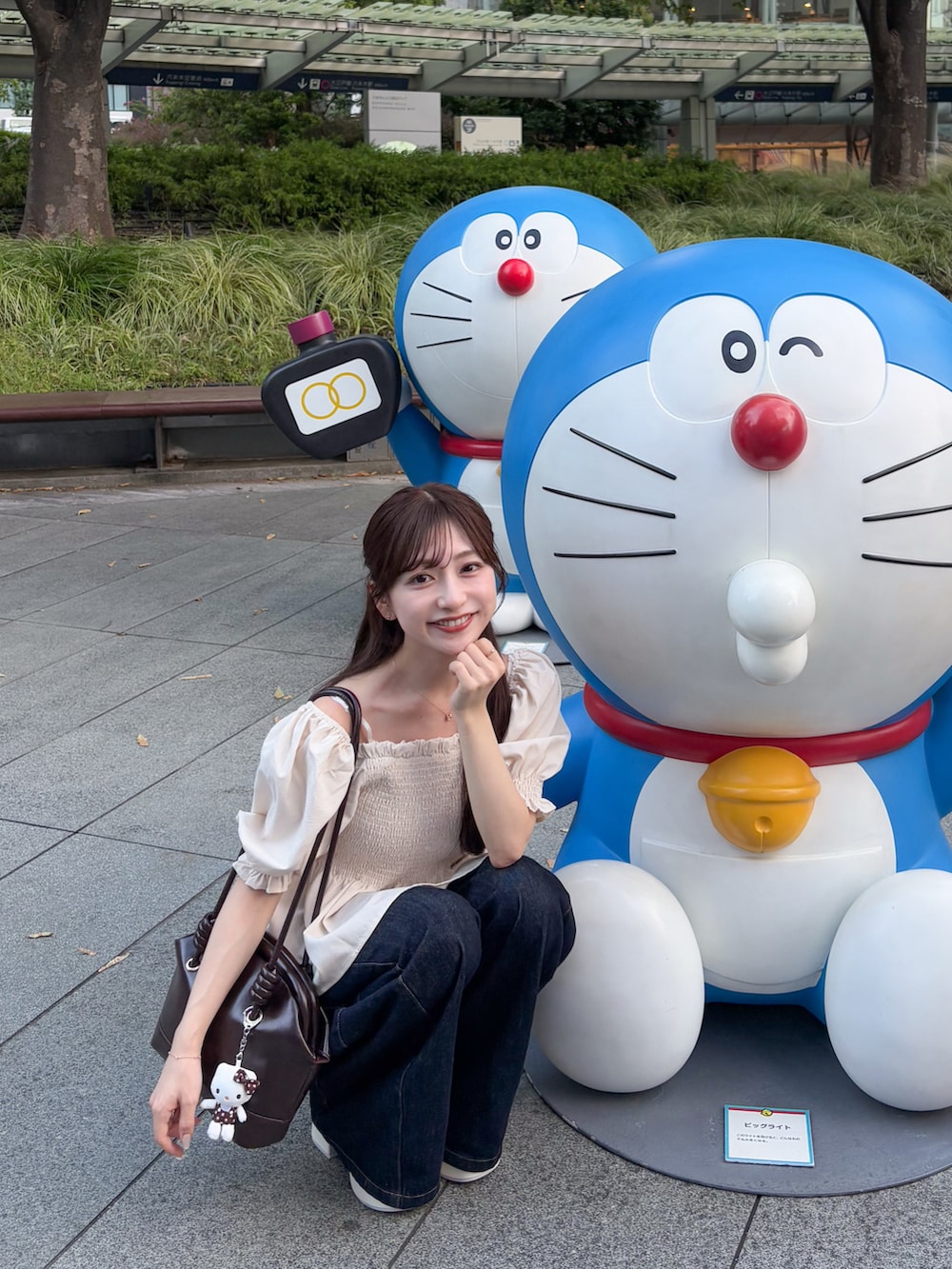 ブルー系のデニムパンツ、ホワイト系のトップス、ブラウン系のショルダーバッグを着用したレディースの夏コーディネートの3枚目の写真
