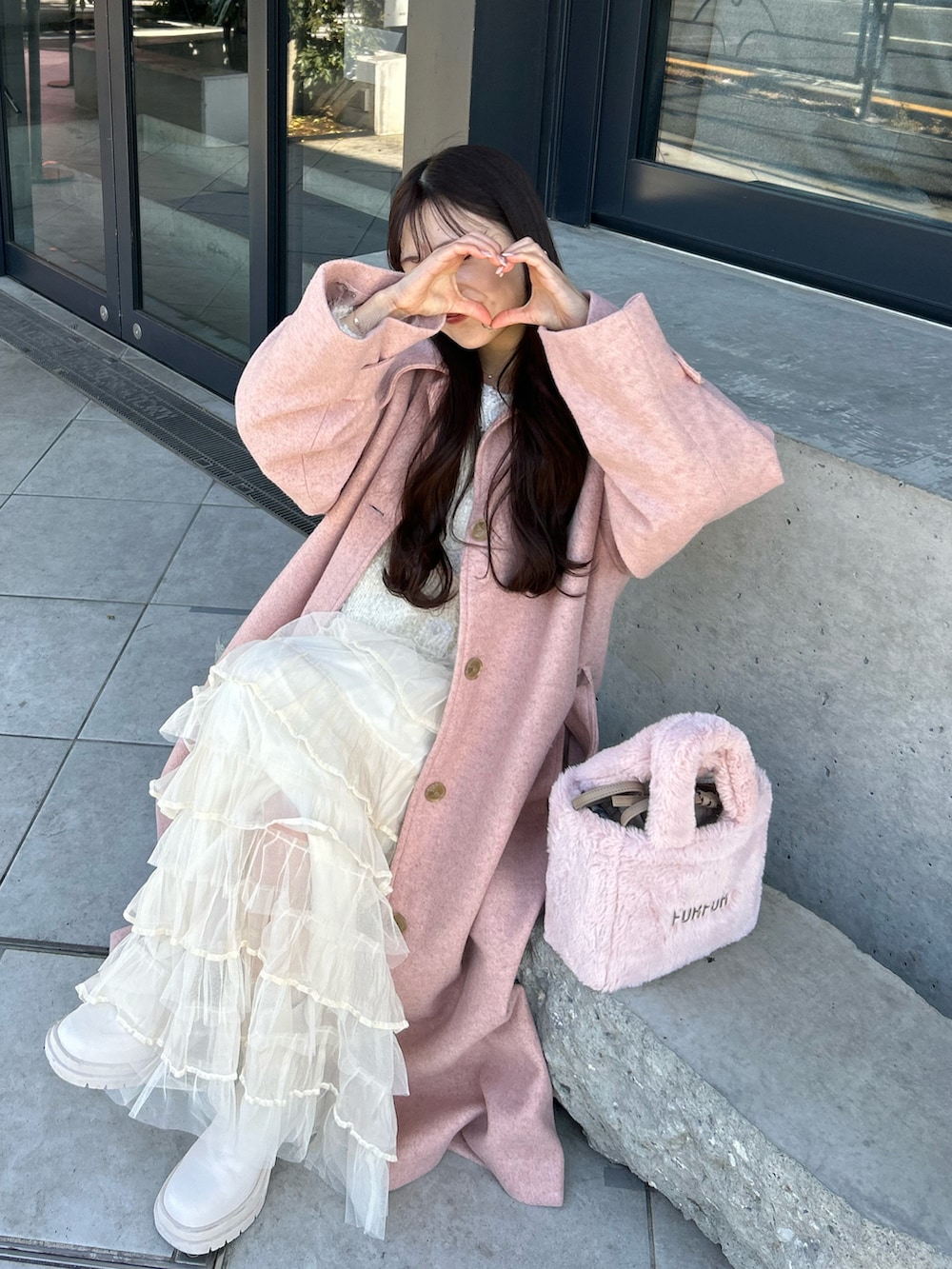 ピンク系のジャケット/アウター、ピンク系のトートバッグ、ホワイト系のブーツを着用したレディースの冬コーディネートの2枚目の写真