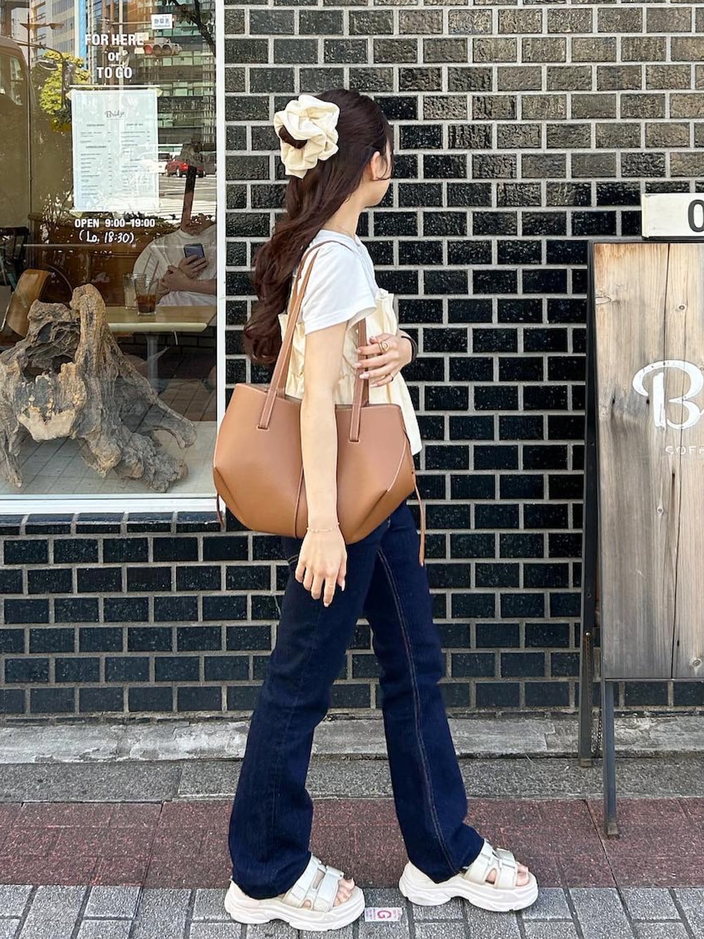 ブラウン系のバッグ、ホワイト系のサンダル、ホワイト系のTシャツ/カットソーを着用したレディースの夏コーディネートの4枚目の写真