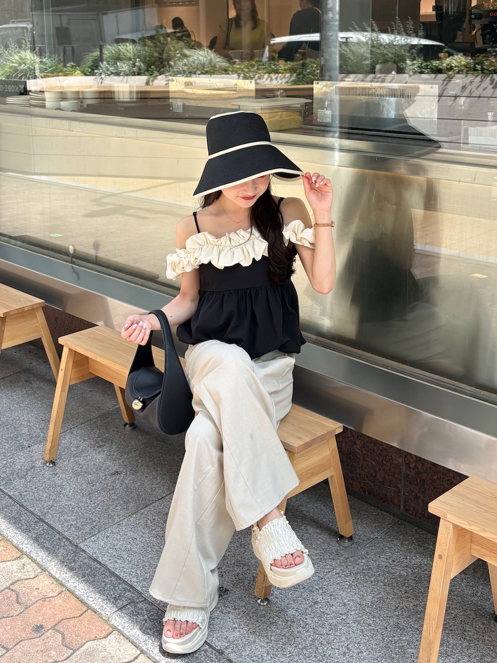 ホワイト系のスラックス、ホワイト系のサンダル、ホワイト系のトップスを着用したレディースの夏コーディネートの3枚目の写真