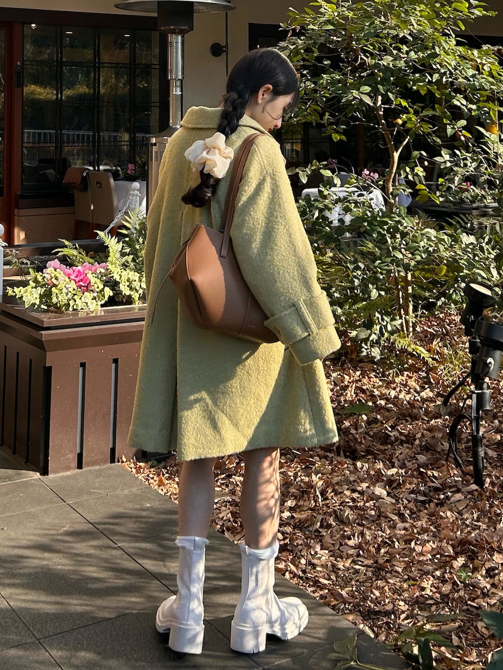 ホワイト系のニット/セーター、ブラウン系のバッグ、ホワイト系のスカートを着用したレディースの冬コーディネートの2枚目の写真