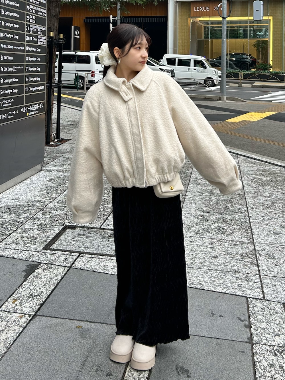 ブラック系のスカート、ホワイト系のショルダーバッグ、ホワイト系のニット/セーターを着用したレディースの冬コーディネートの3枚目の写真
