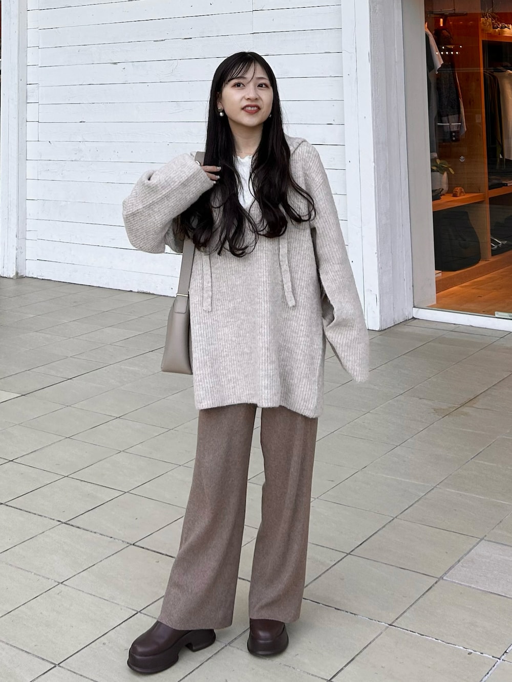 ブラウン系のブーツ、ブラウン系のパンツ、ベージュ系のバッグを着用したレディースの冬コーディネートの5枚目の写真