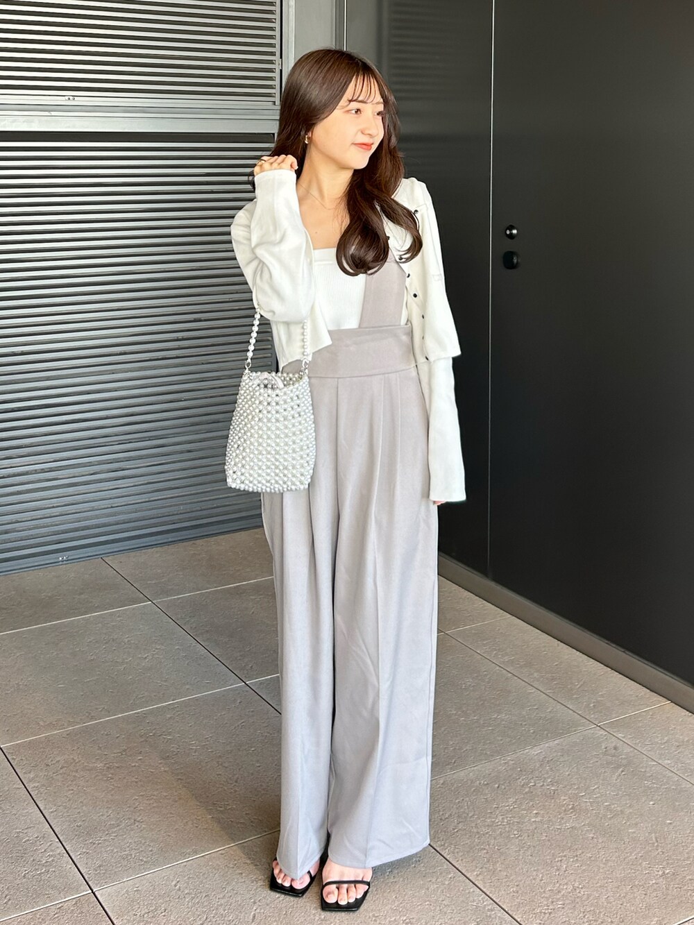 ホワイト系のキャミソール、グレー系のその他パンツ、シルバー系のバッグを着用したレディースの春コーディネートの4枚目の写真