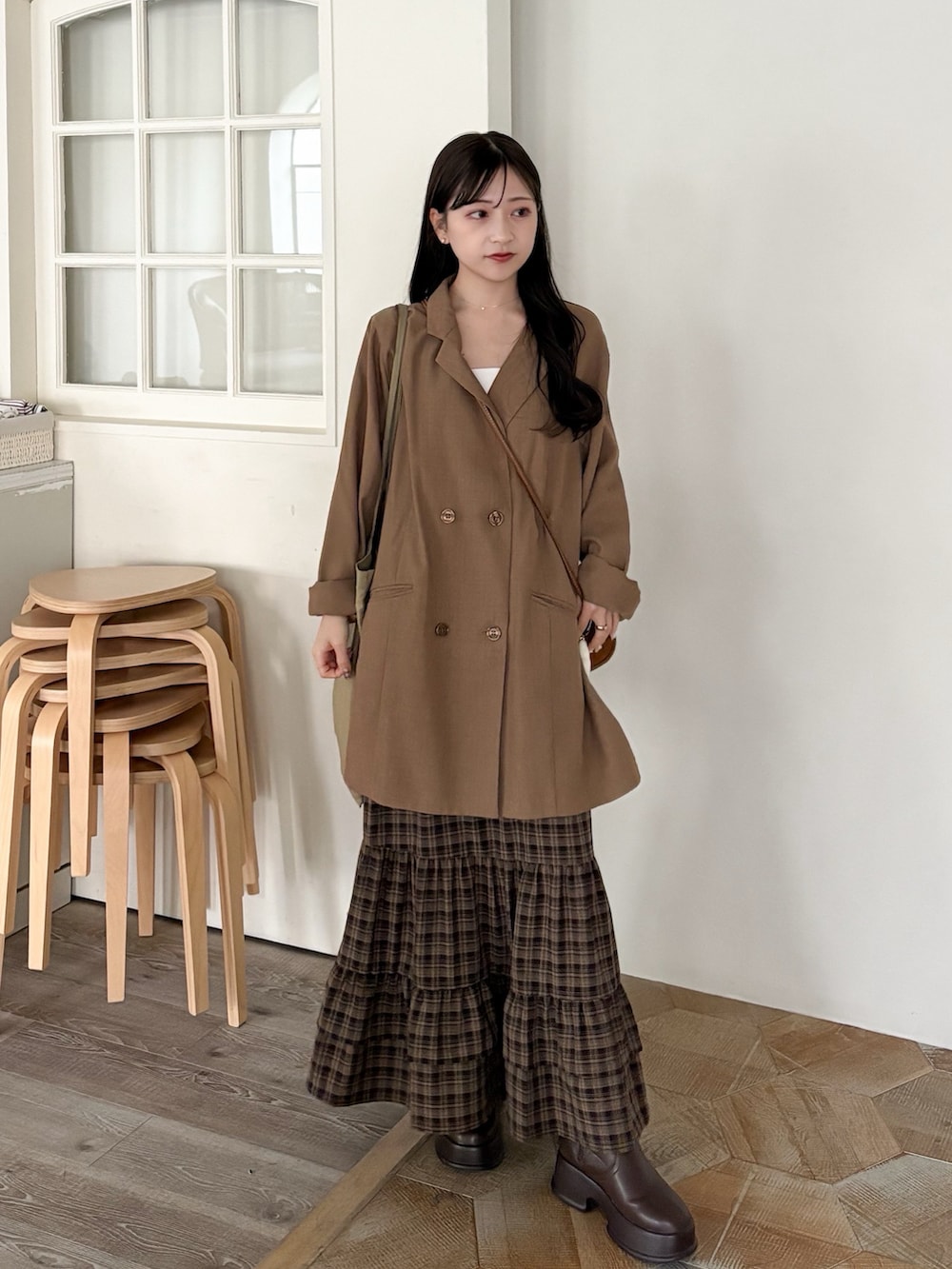 イエロー系のショルダーバッグ、ブラウン系のテーラードジャケット、ブラウン系のブーツを着用したレディースの秋コーディネートの2枚目の写真