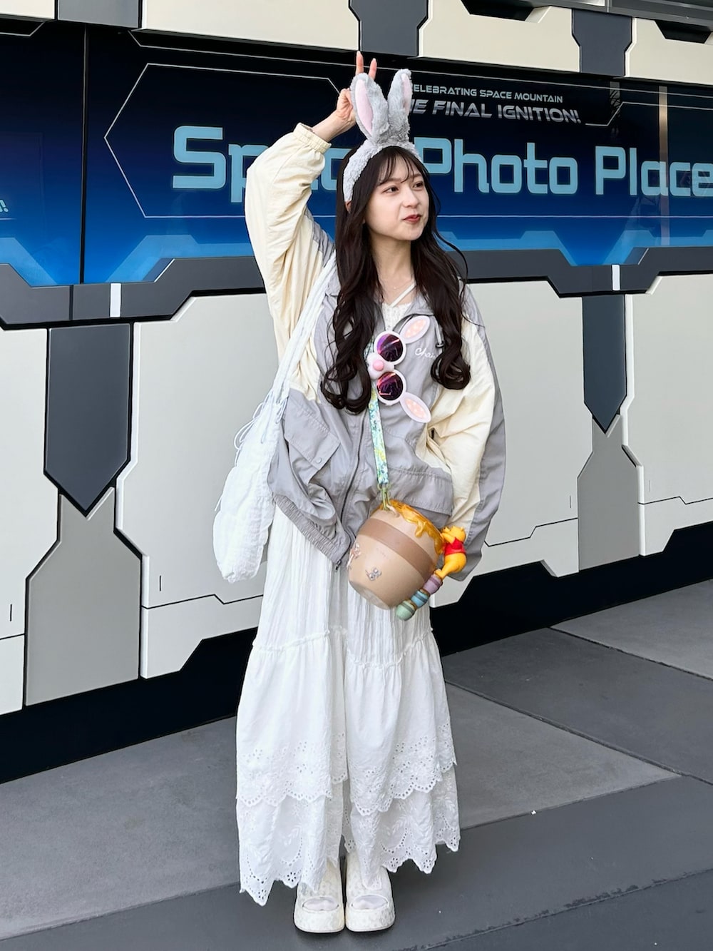 グレー系のナイロンジャケット、ホワイト系のスカート、ホワイト系のトートバッグを着用したレディースの春コーディネートの4枚目の写真