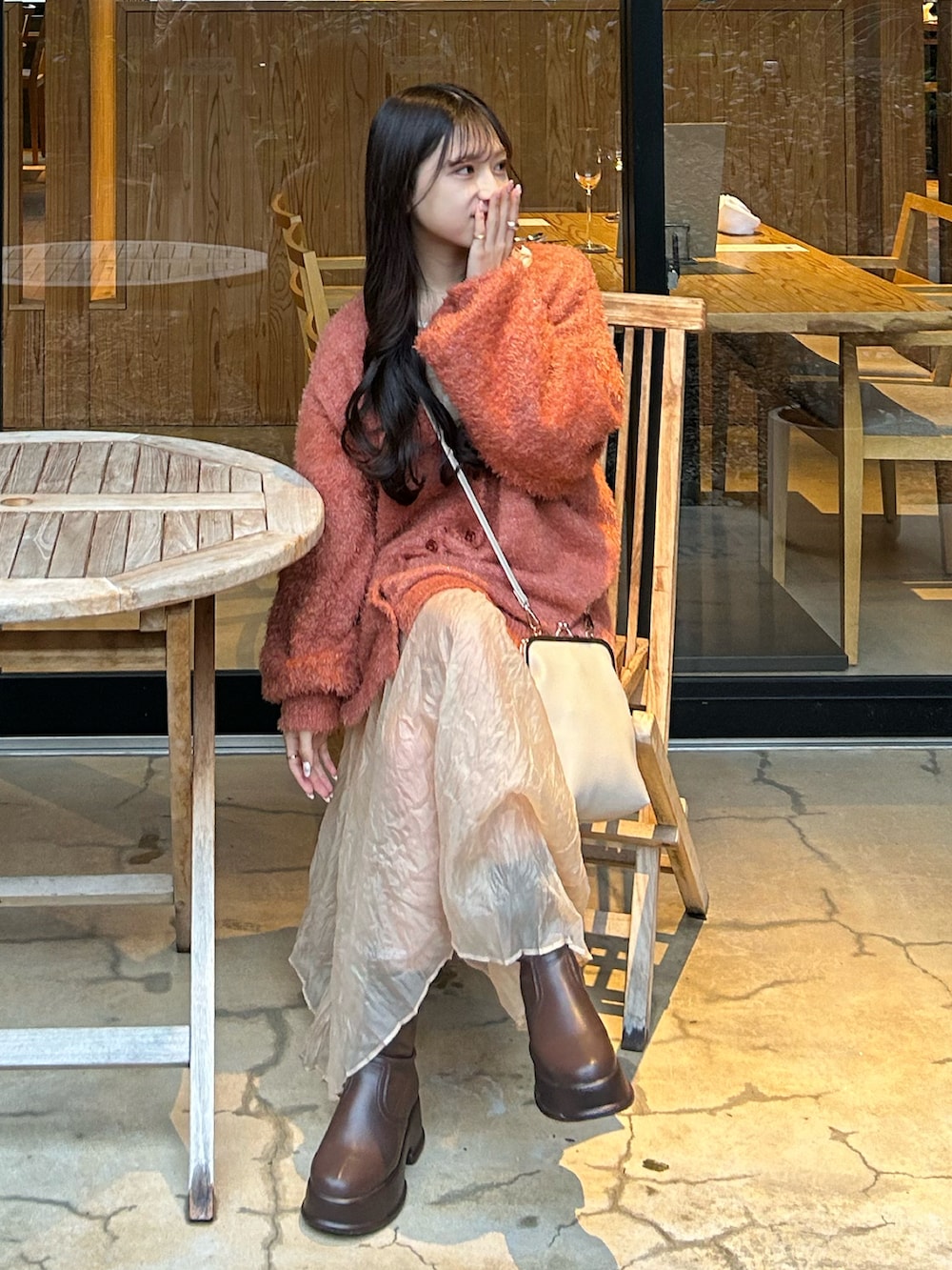 ホワイト系のその他アウター、ブラウン系のブーツ、オレンジ系のカーディガン/ボレロを着用したレディースの冬コーディネートの3枚目の写真