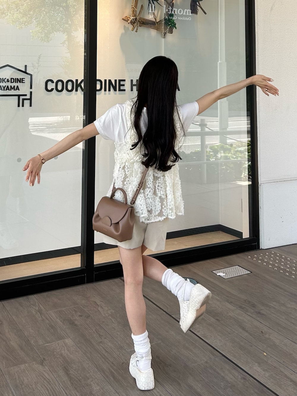 ブラウン系のバッグ、ホワイト系のキャミソール、ホワイト系のTシャツ/カットソーを着用したレディースの春コーディネートの5枚目の写真