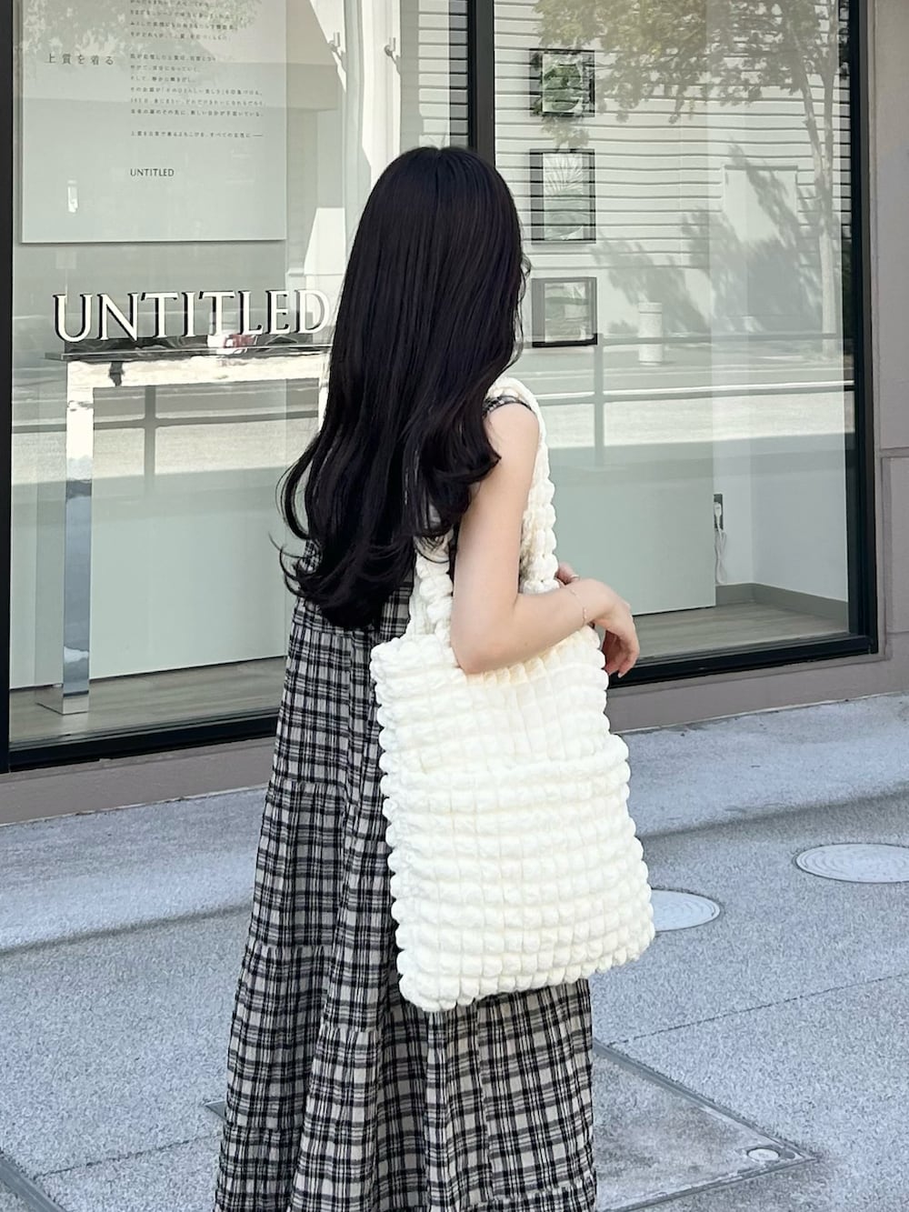 ホワイト系のサンダル、ブラック系のワンピース/ドレス、ホワイト系のトートバッグを着用したレディースの夏コーディネートの4枚目の写真