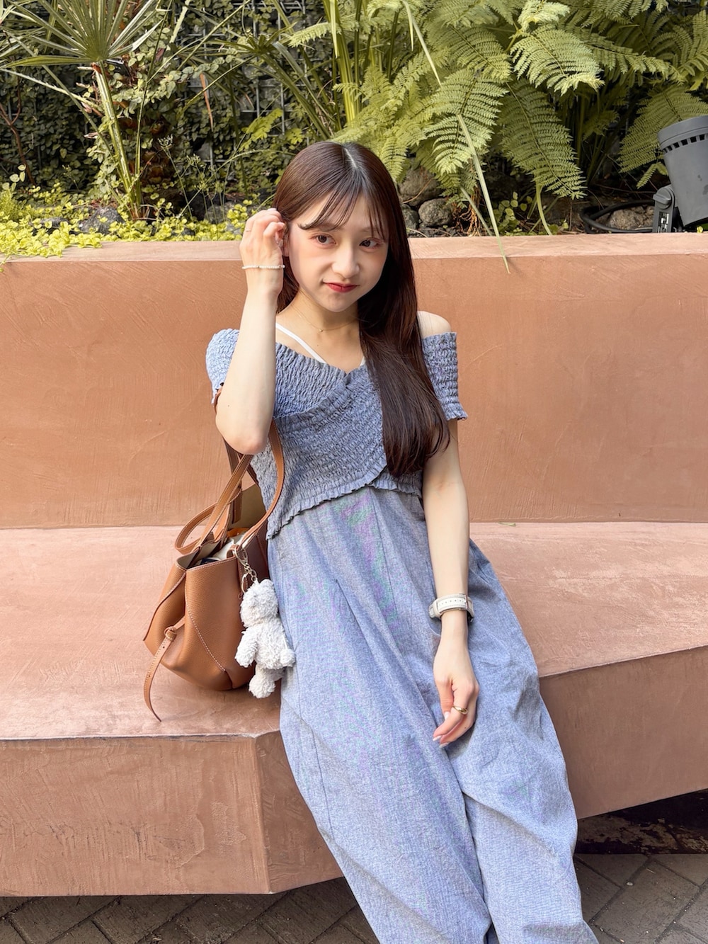 ホワイト系のサンダル、グレー系のサロペット/オーバーオール、ブラウン系のバッグを着用したレディースの夏コーディネートの2枚目の写真