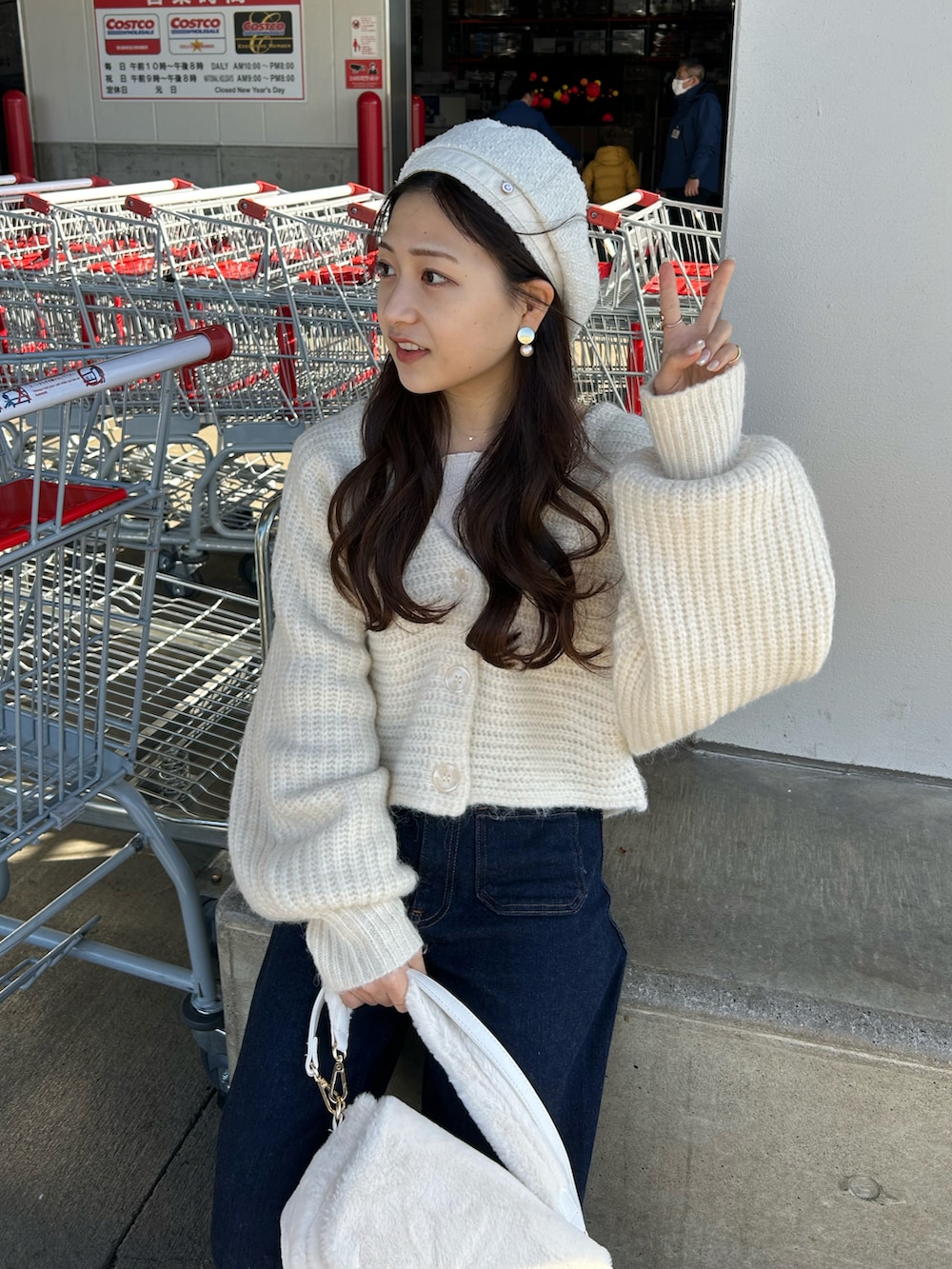 ブルー系のデニムパンツ、ホワイト系のショルダーバッグ、ホワイト系のローファーを着用したレディースの冬コーディネートの4枚目の写真