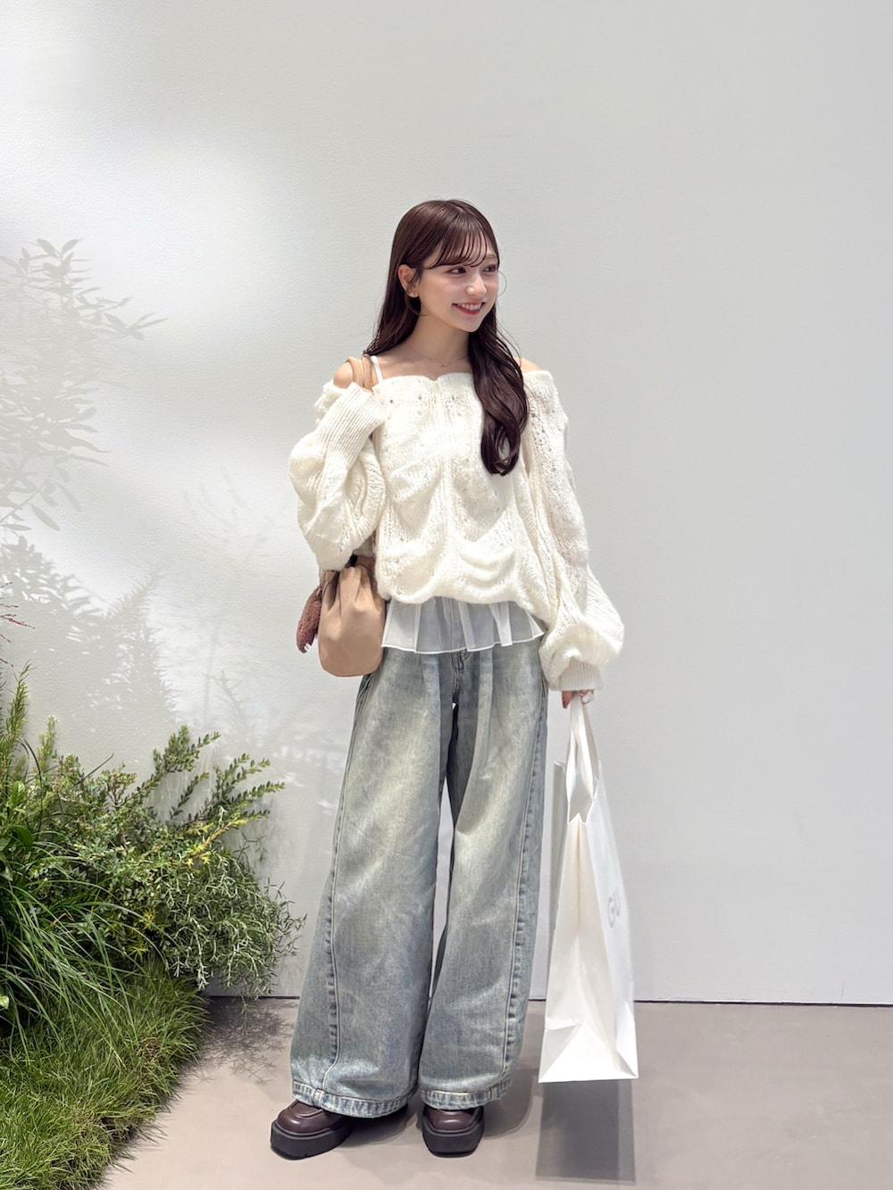 ホワイト系のニット/セーター、ブルー系のデニムパンツ、ブラウン系のローファーを着用したレディースの秋コーディネートの2枚目の写真