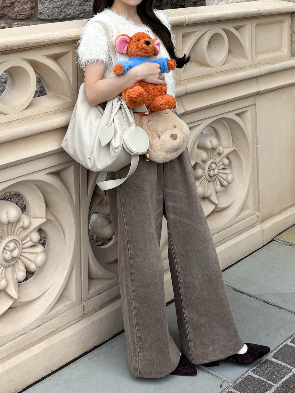 ブラウン系のパンプス、ブラウン系のデニムパンツ、ホワイト系のボストンバッグを着用したレディースの秋コーディネートの3枚目の写真