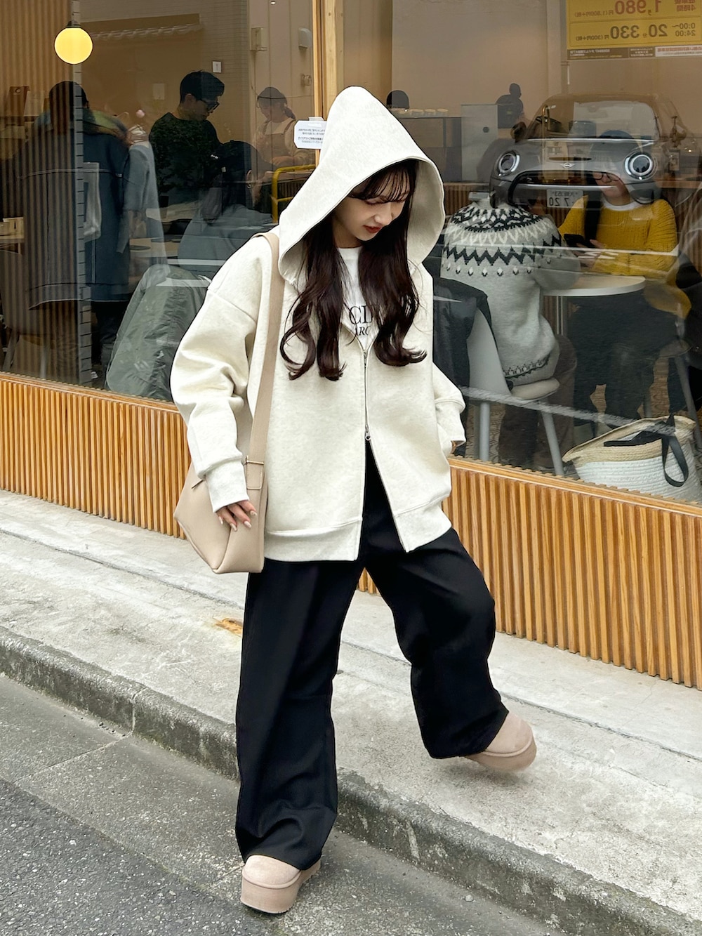 ブラック系のスラックス、ホワイト系のブルゾン、ベージュ系のバッグを着用したレディースの冬コーディネートの3枚目の写真