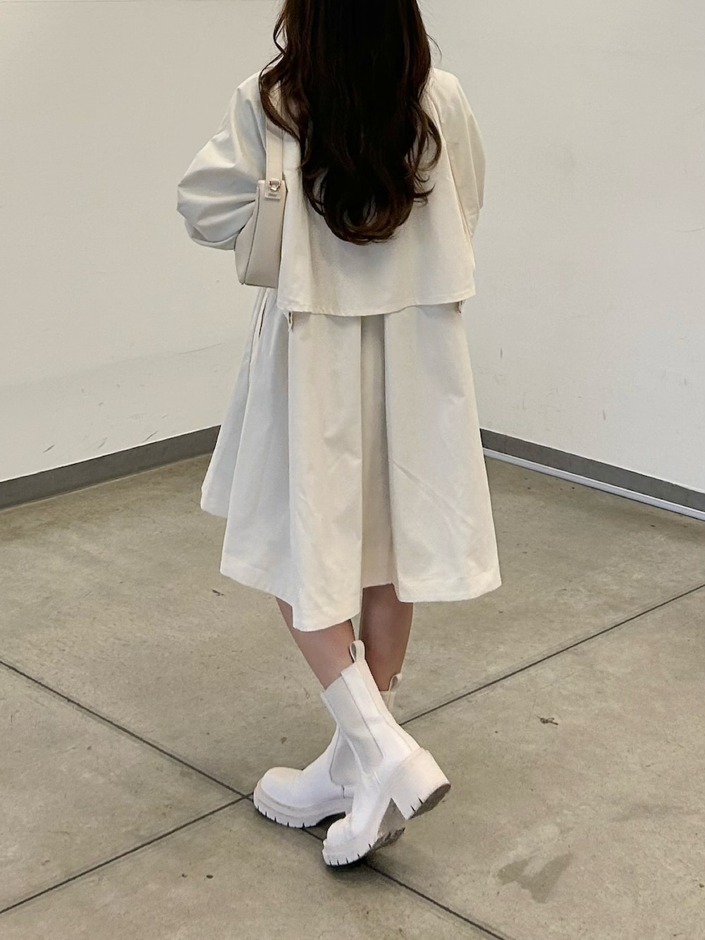 ホワイト系のトレンチコート、ホワイト系のTシャツ/カットソー、ホワイト系のショルダーバッグを着用したレディースの春コーディネートの3枚目の写真