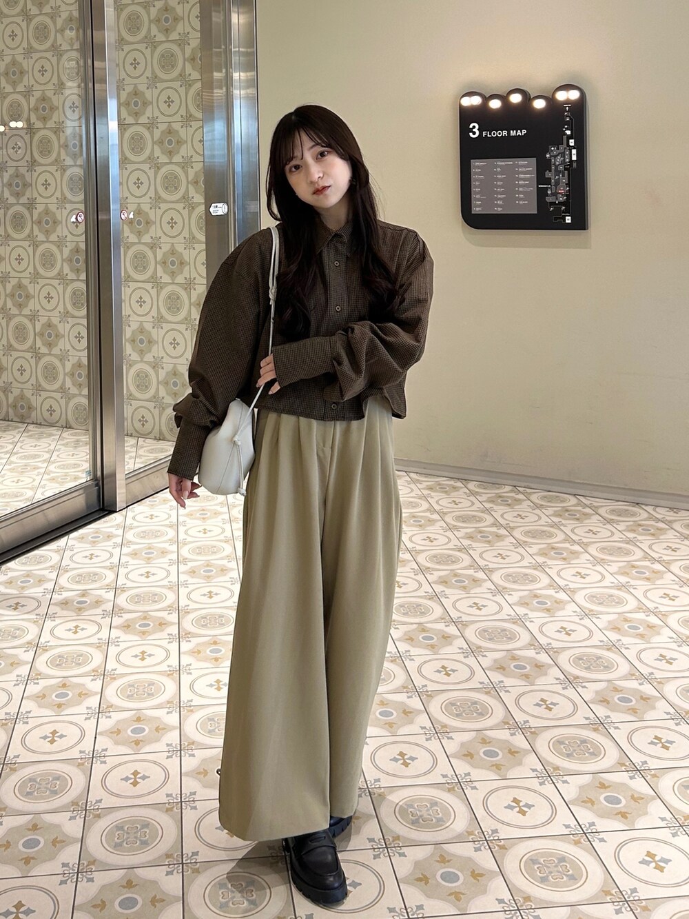 ブラウン系のシャツ/ブラウス、ホワイト系のその他アウター、ベージュ系のその他パンツを着用したレディースの冬コーディネートの4枚目の写真