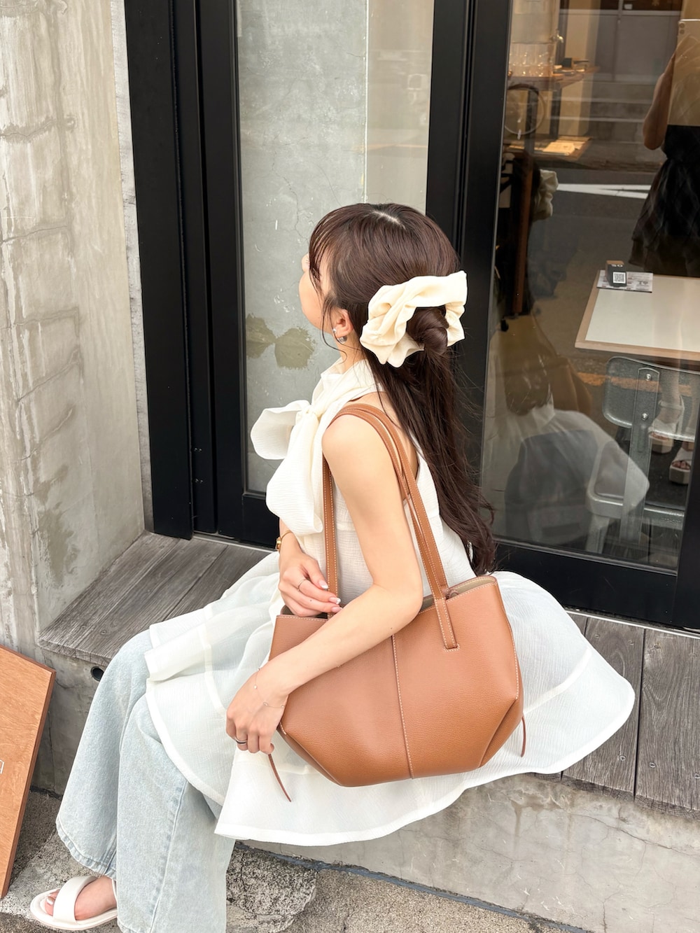 ホワイト系のサンダル、ホワイト系のシャツ/ブラウス、ブルー系のデニムパンツを着用したレディースの夏コーディネートの2枚目の写真