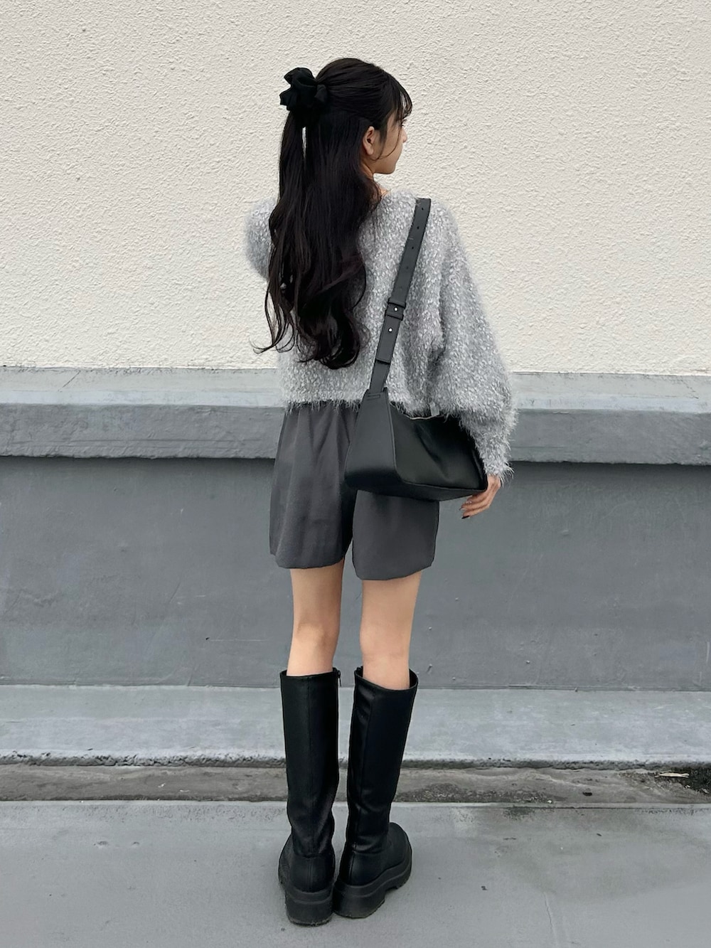 ブラック系のブーツ、グレー系のスカート、グレー系のカーディガン/ボレロを着用したレディースの冬コーディネートの3枚目の写真