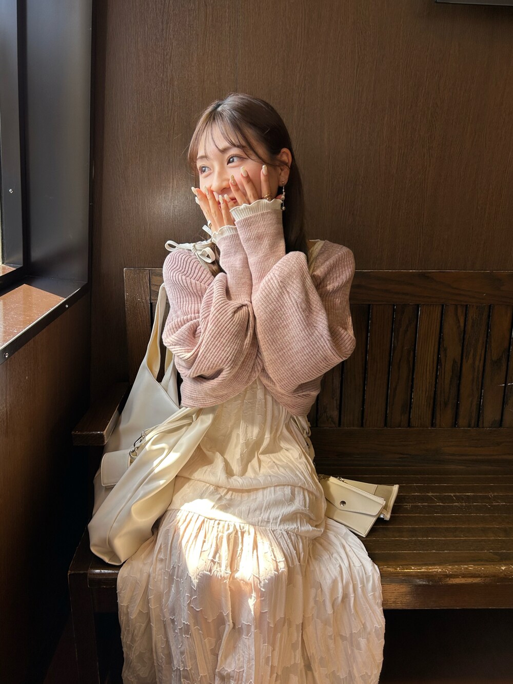 ホワイト系のワンピース、ベージュ系のショルダーバッグ、ピンク系のカーディガン/ボレロを着用したレディースの春コーディネートの4枚目の写真