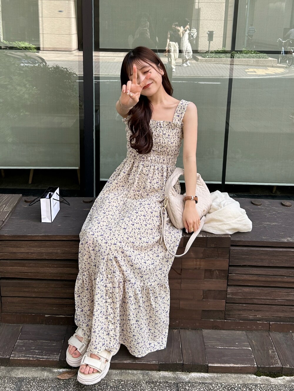 イエロー系のワンピース、ホワイト系のショルダーバッグ、ホワイト系のサンダルを着用したレディースの夏コーディネートの4枚目の写真