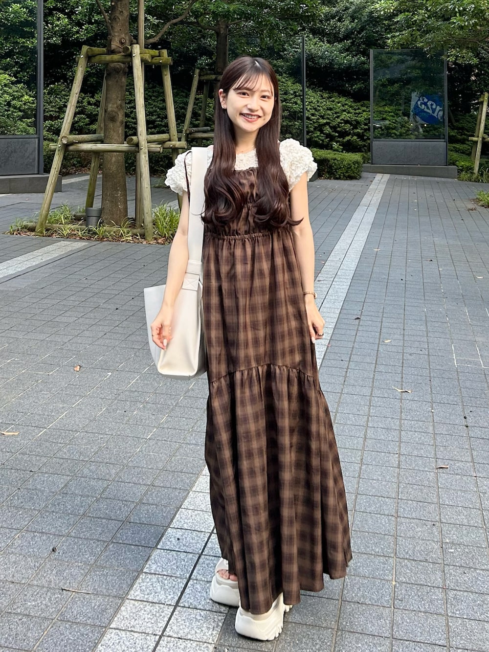 ブラウン系のワンピース、ホワイト系のトートバッグ、ホワイト系のサンダルを着用したレディースの夏コーディネートの4枚目の写真