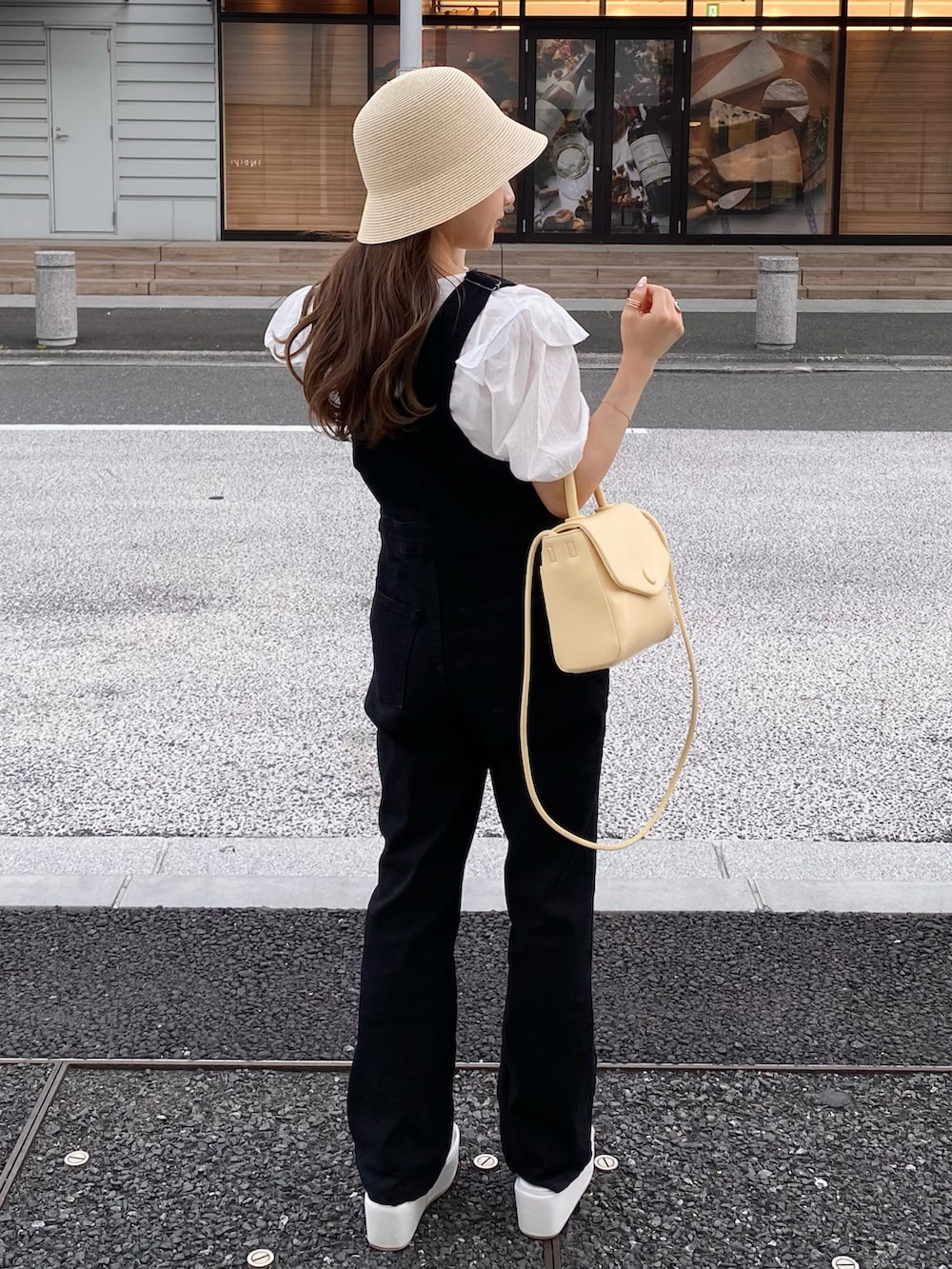 ホワイト系のシャツ/ブラウス、イエロー系のショルダーバッグ、ブラック系のサロペット/オーバーオールを着用したレディースの夏コーディネートの2枚目の写真