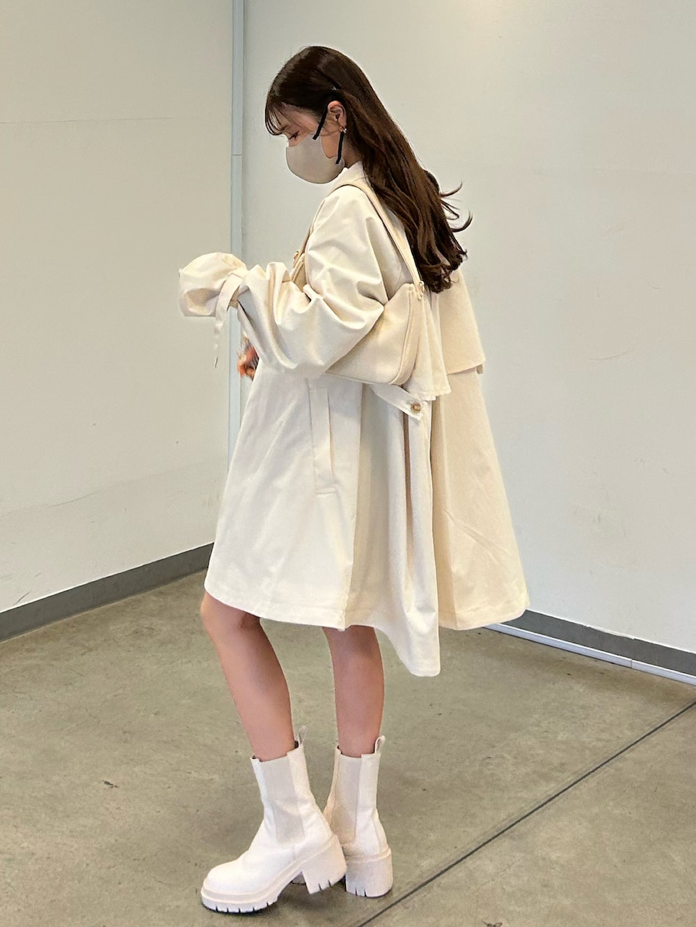 ホワイト系のトレンチコート、ホワイト系のTシャツ/カットソー、ホワイト系のショルダーバッグを着用したレディースの春コーディネートの4枚目の写真