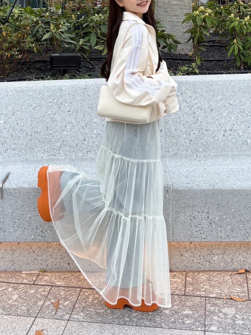 ホワイト系のスカート、オレンジ系のサンダル、ホワイト系のジャージを着用したレディースの春コーディネートの3枚目の写真