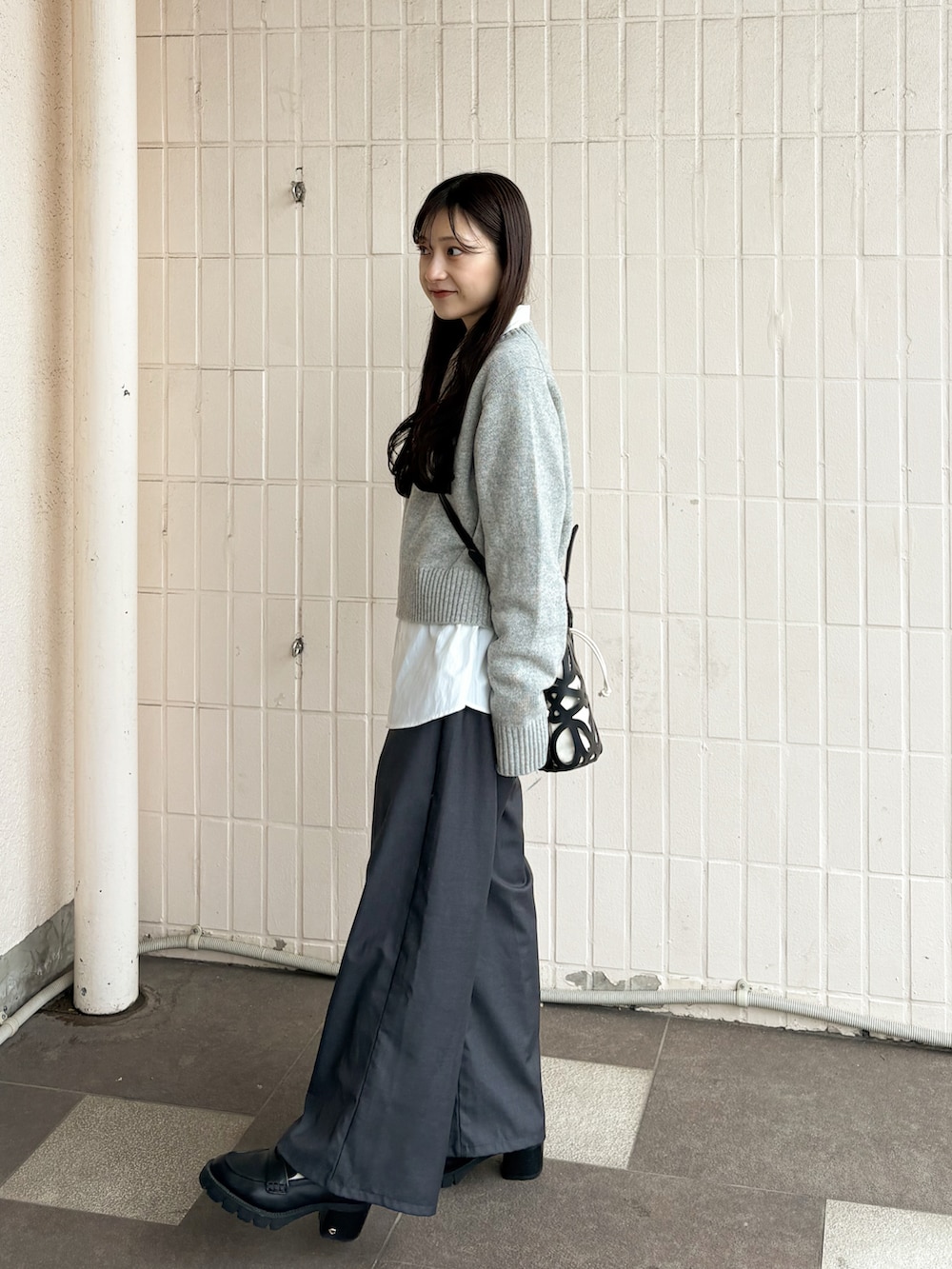 ブラック系のシューズ、グレー系のニット/セーター、ホワイト系のシャツ/ブラウスを着用したレディースの春コーディネートの4枚目の写真