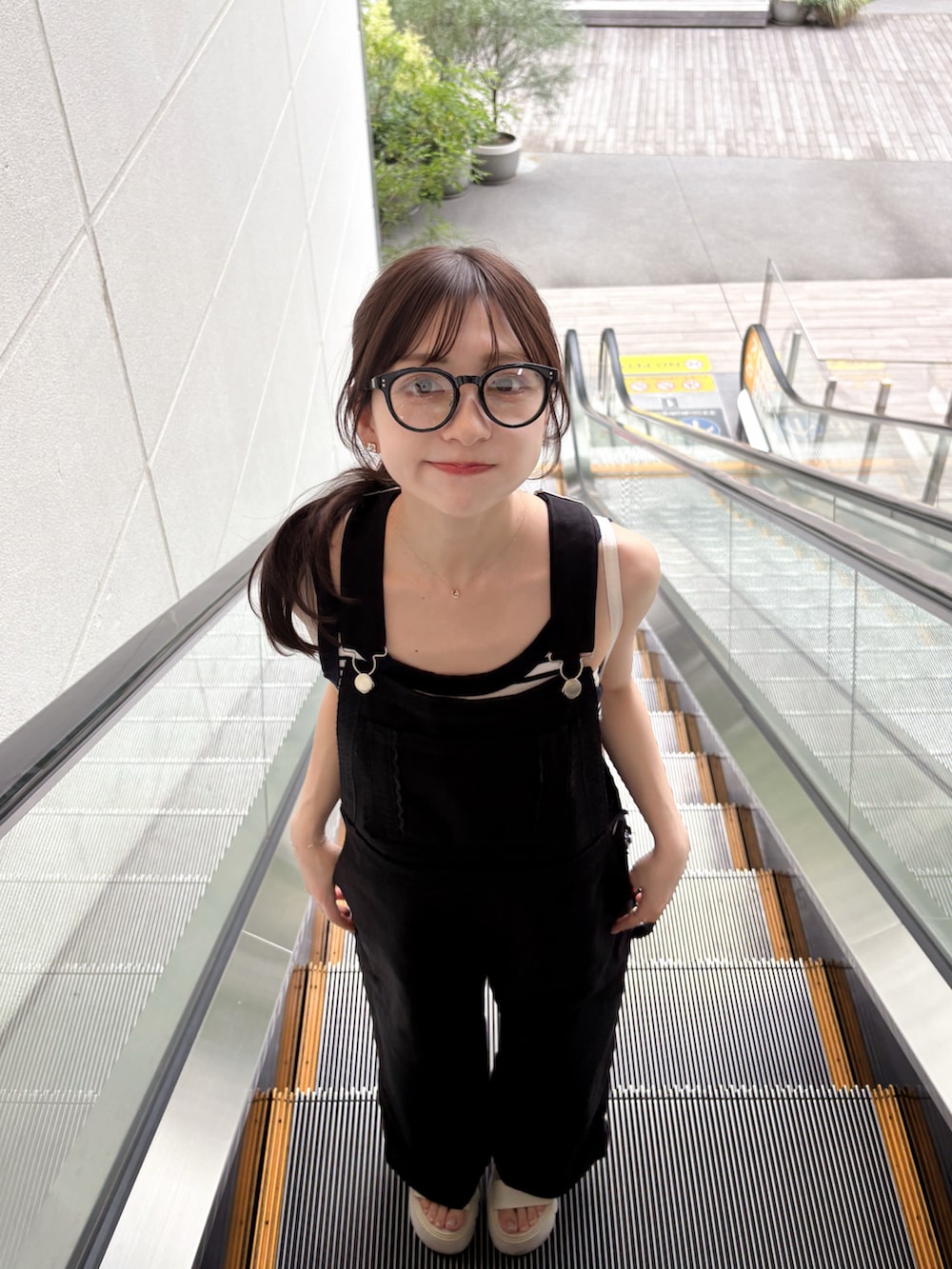 ホワイト系のトートバッグ、ブラック系のデニムパンツ、ホワイト系のサンダルを着用したレディースの夏コーディネートの4枚目の写真