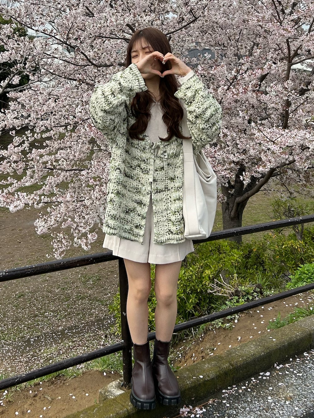 ホワイト系のトートバッグ、ホワイト系のその他パンツ、ブラウン系のブーツを着用したレディースの春コーディネートの2枚目の写真