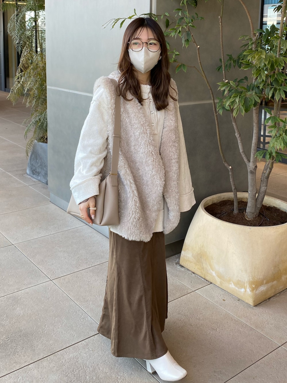 ホワイト系のブーツ、ブラウン系のスカート、ホワイト系のTシャツ/カットソーを着用したレディースの冬コーディネートの3枚目の写真