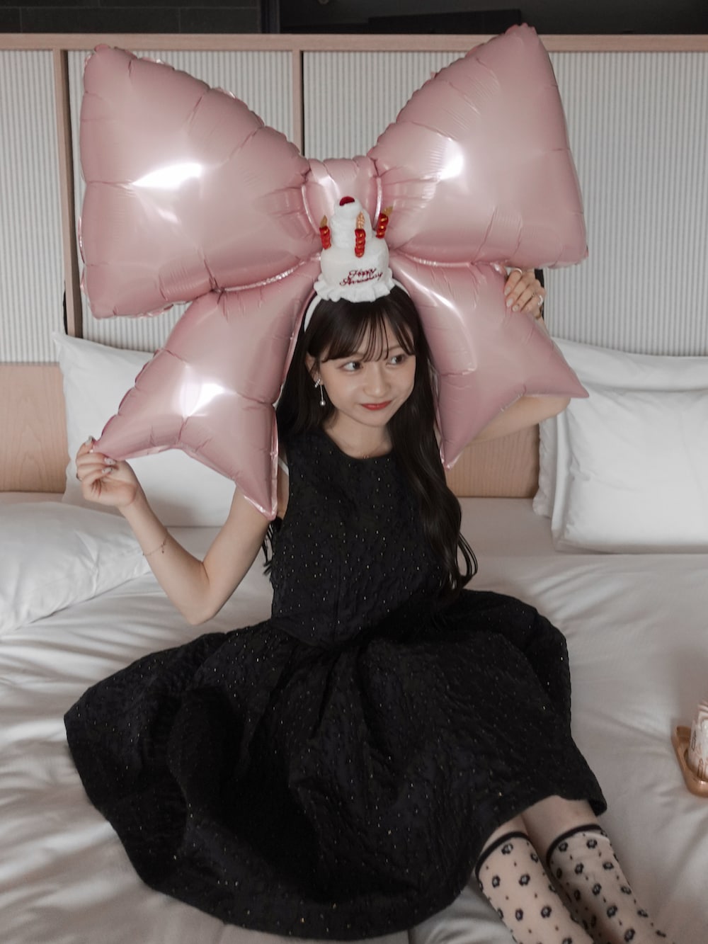 ホワイト系のパンプス、ホワイト系のハンドバッグ、ブラック系のドレスを着用したレディースの夏コーディネートの4枚目の写真