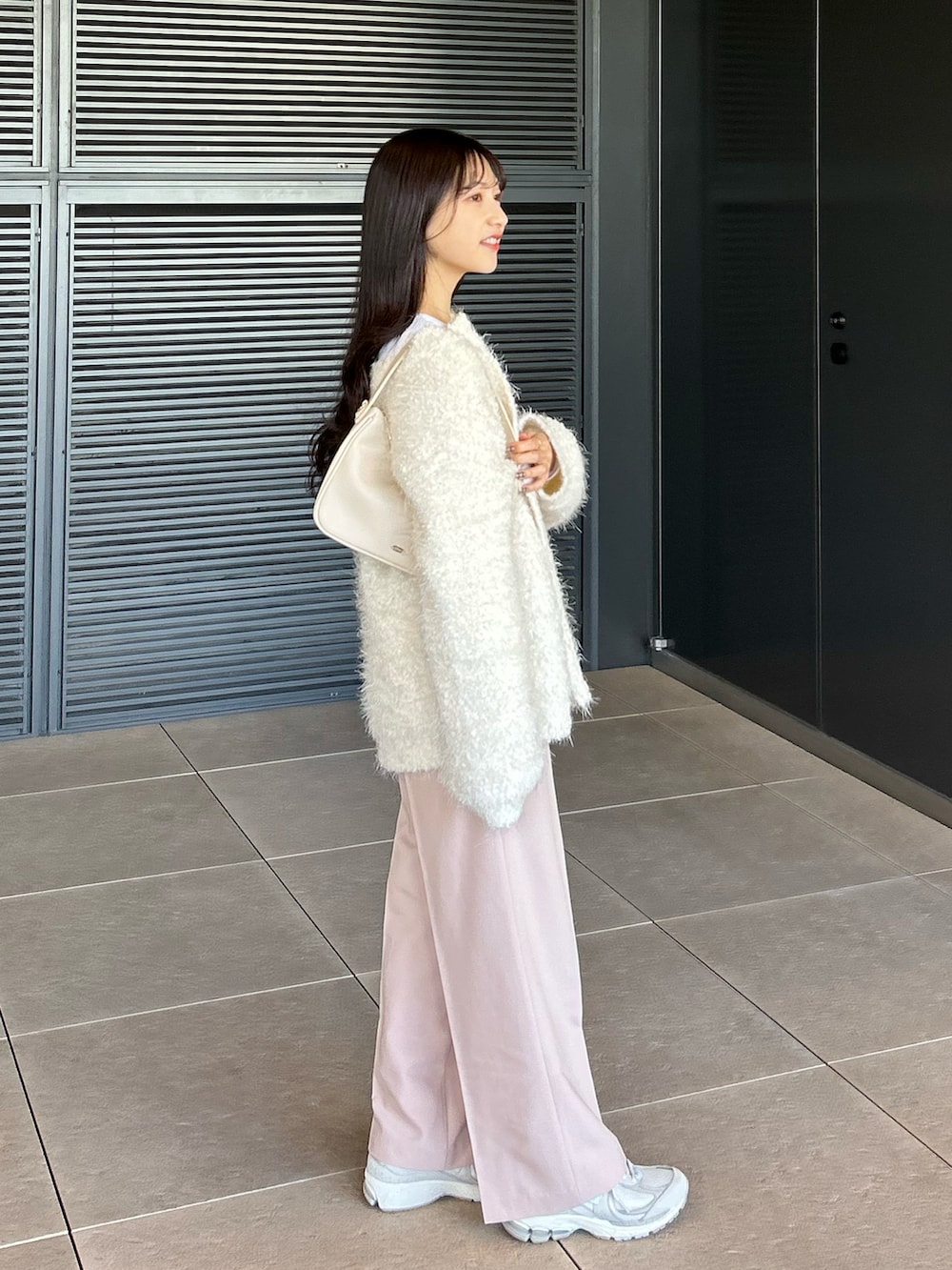 ピンク系のパンツ、ブルー系のTシャツ/カットソー、ホワイト系のカーディガン/ボレロを着用したレディースの冬コーディネートの3枚目の写真