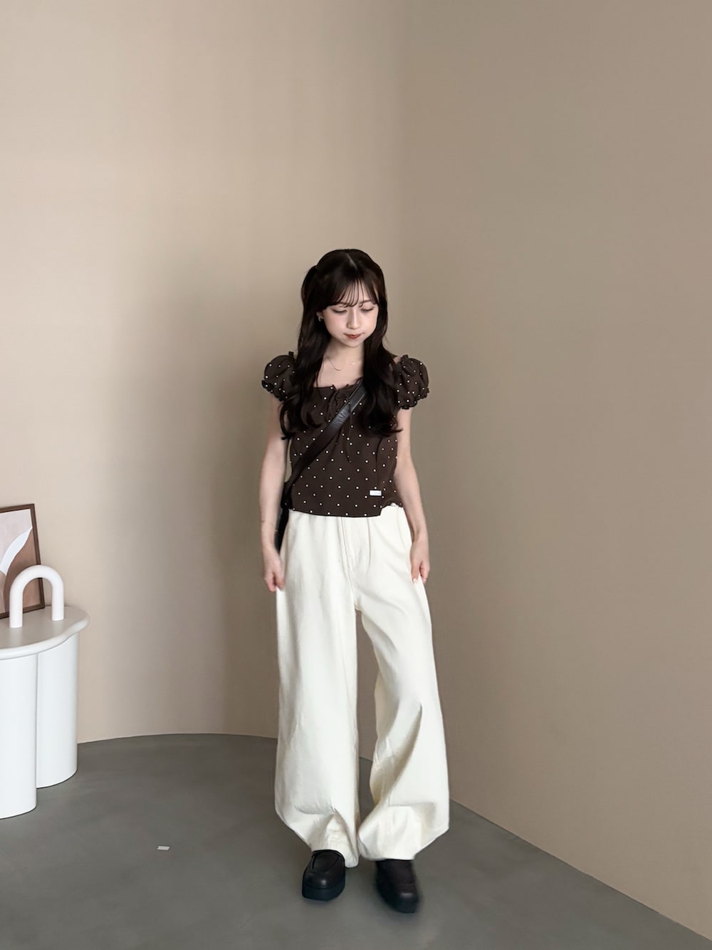 ブラウン系のローファー、ホワイト系のデニムパンツ、ブラウン系のバッグを着用したレディースの秋コーディネートの4枚目の写真